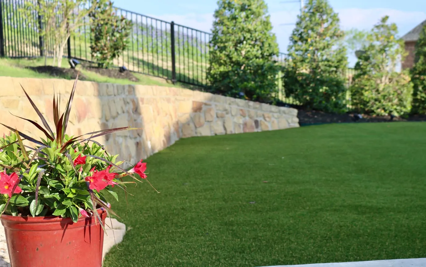 Backyard pool with artificial turf beside Texas bluebonnet field