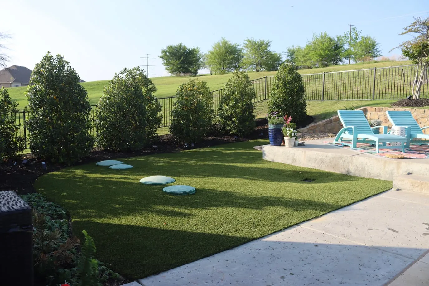 Backyard putting green next to spa and modern home