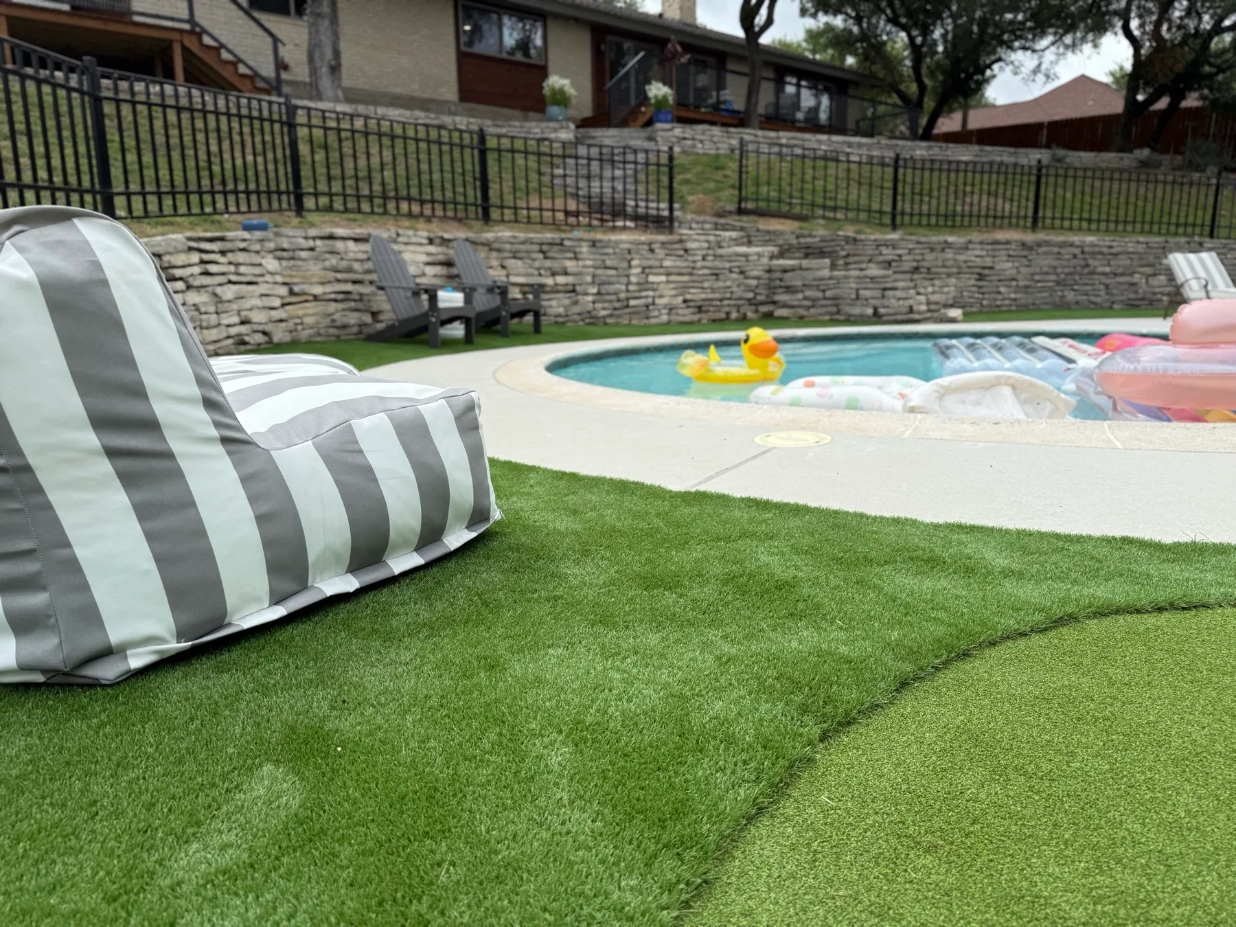 Backyard pool with curved artificial turf surround in DFW