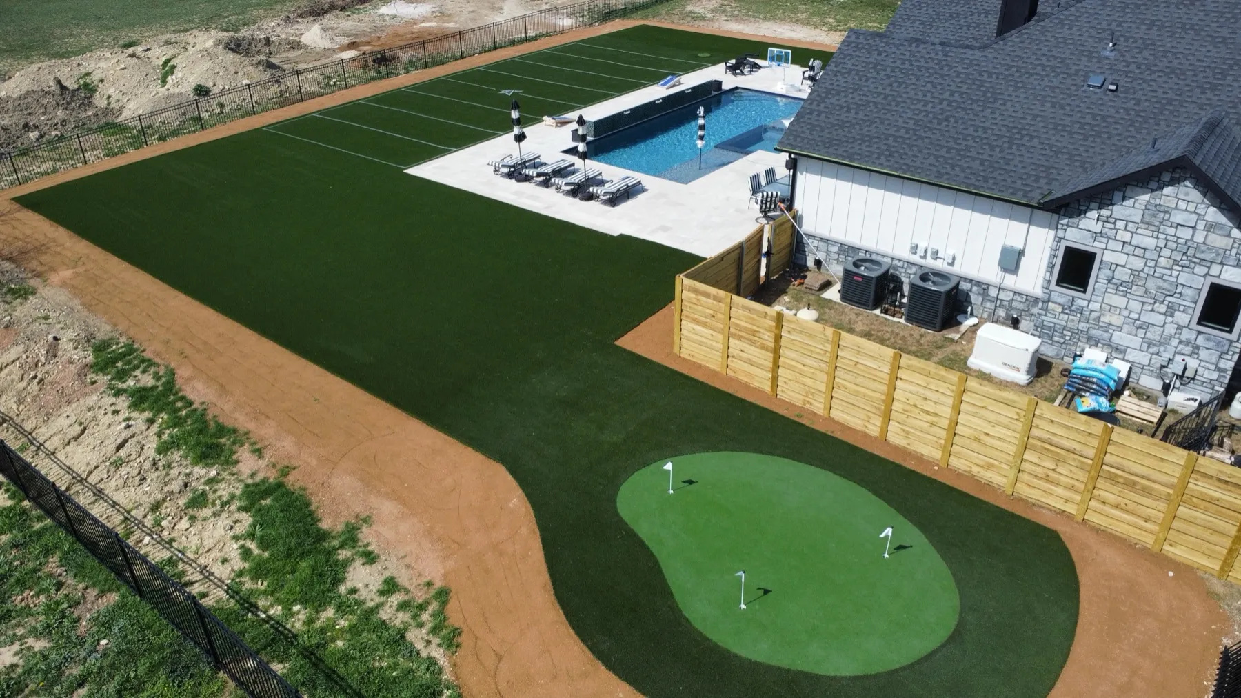 Aerial of backyard putting green and striped football turf