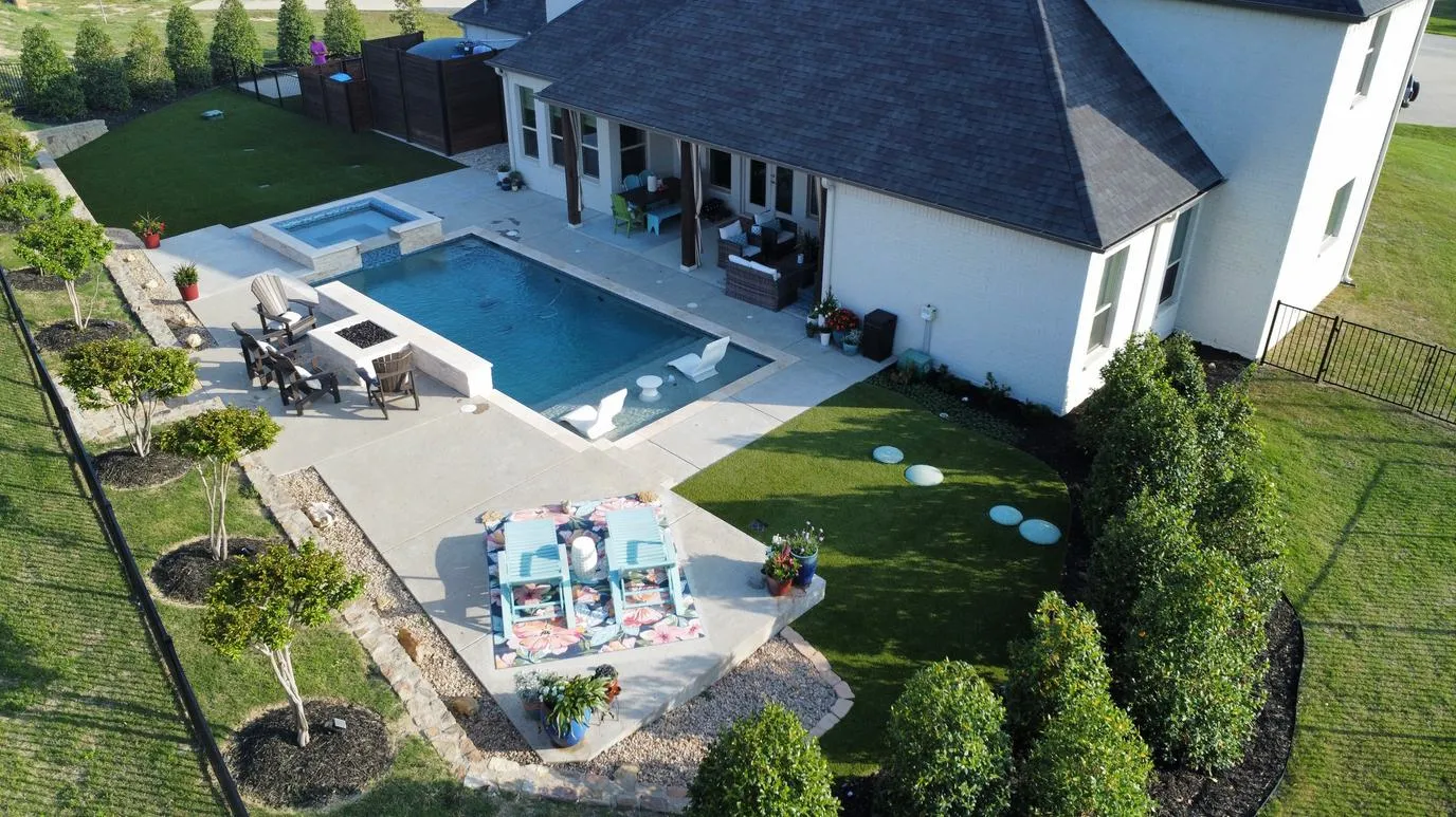 Aerial of backyard pool, spa, and artificial turf in DFW