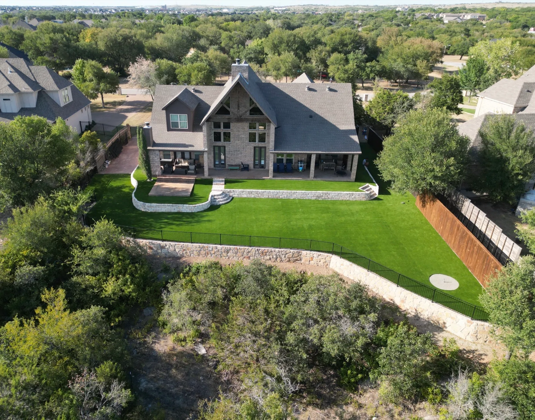 Aerial luxury home with artificial turf backyard in Aledo TX