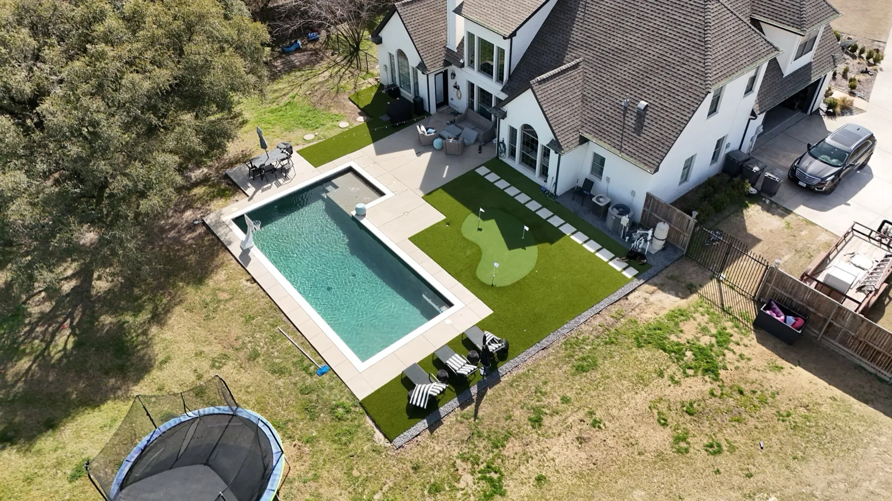 Aledo TX backyard with pool, putting green, and artificial turf