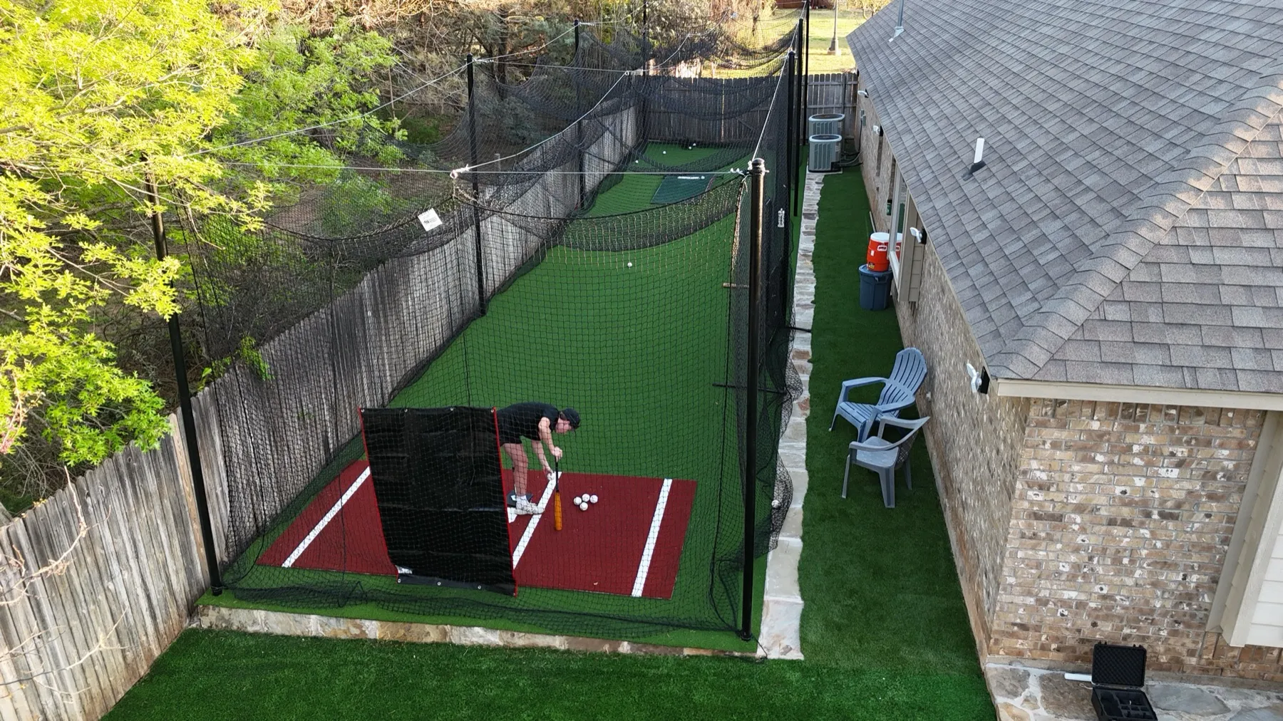 Player taking cuts in backyard batting cage with turf in Aledo, TX