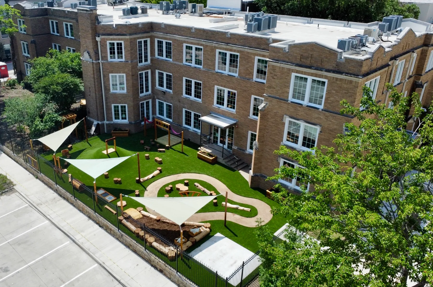 Aerial commercial daycare playground with artificial turf and shade sails