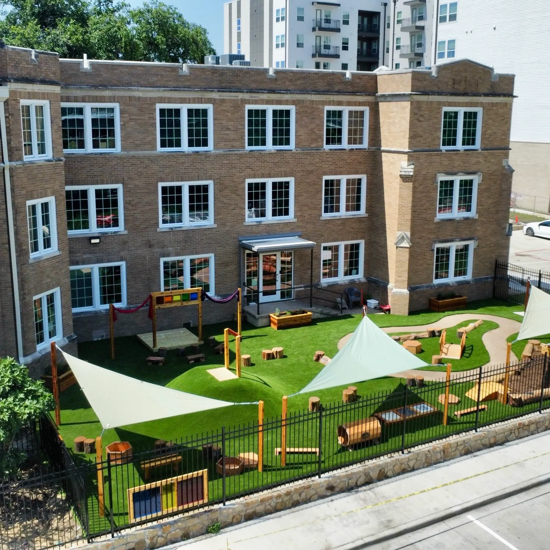 Aerial brick building with artificial turf playground in DFW