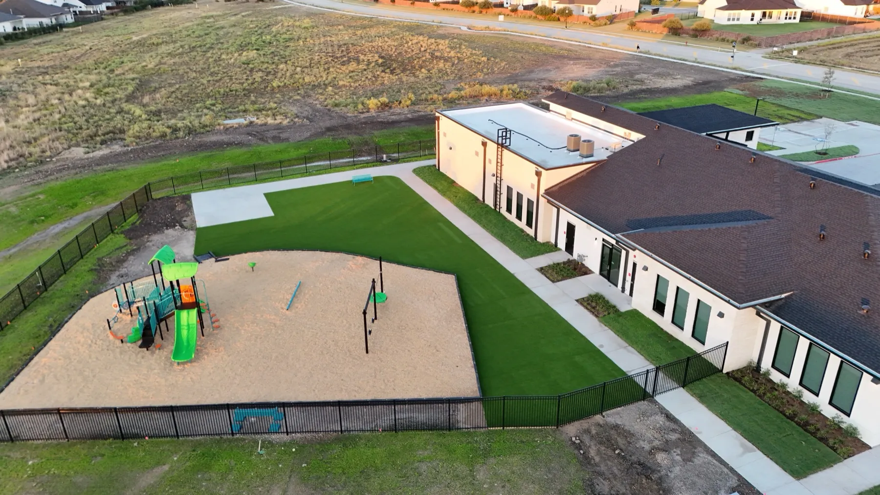 Commercial artificial turf play yard at Aledo TX school with playground
