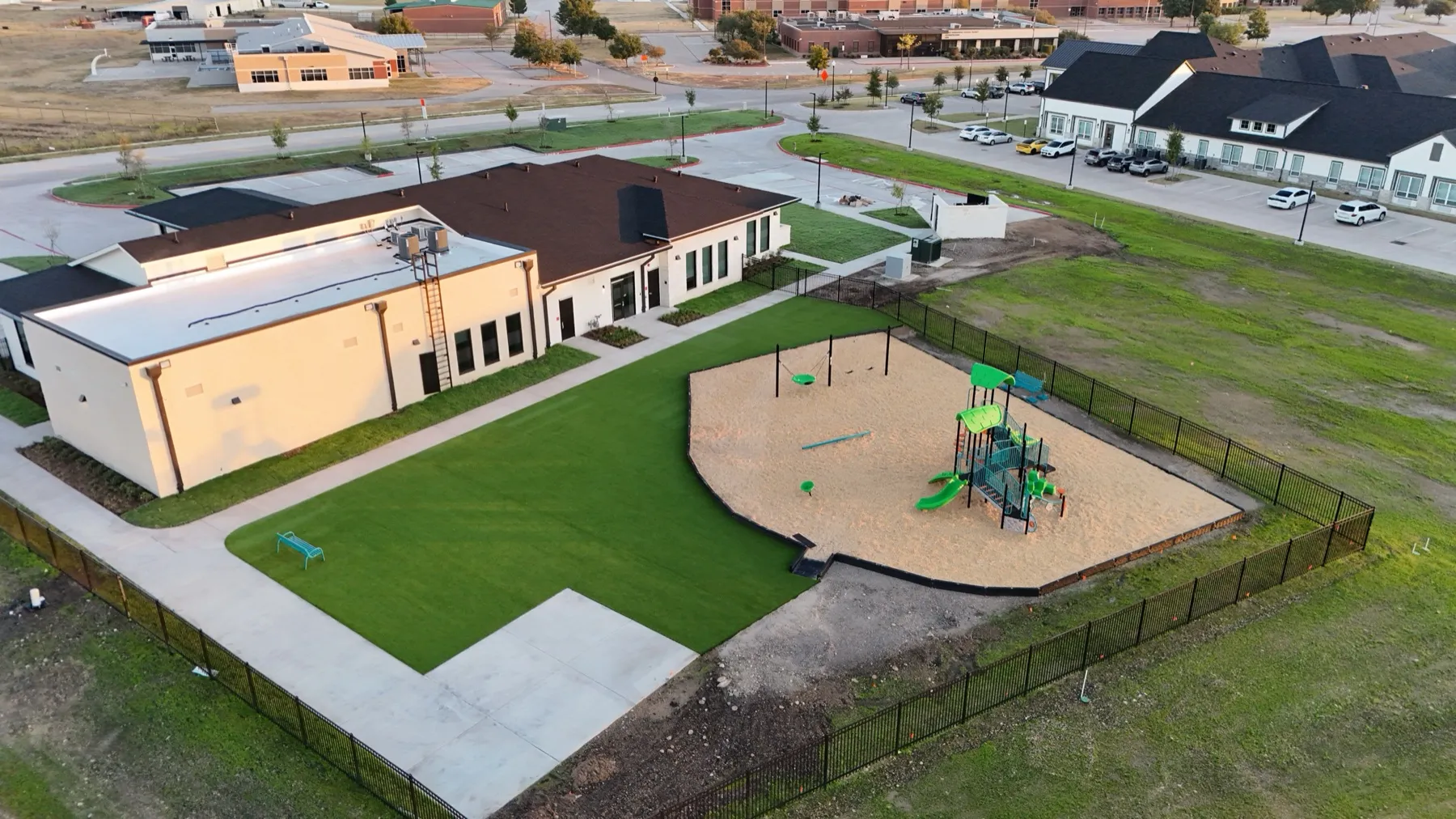 Aerial of Aledo TX school campus with artificial turf lawn and playground