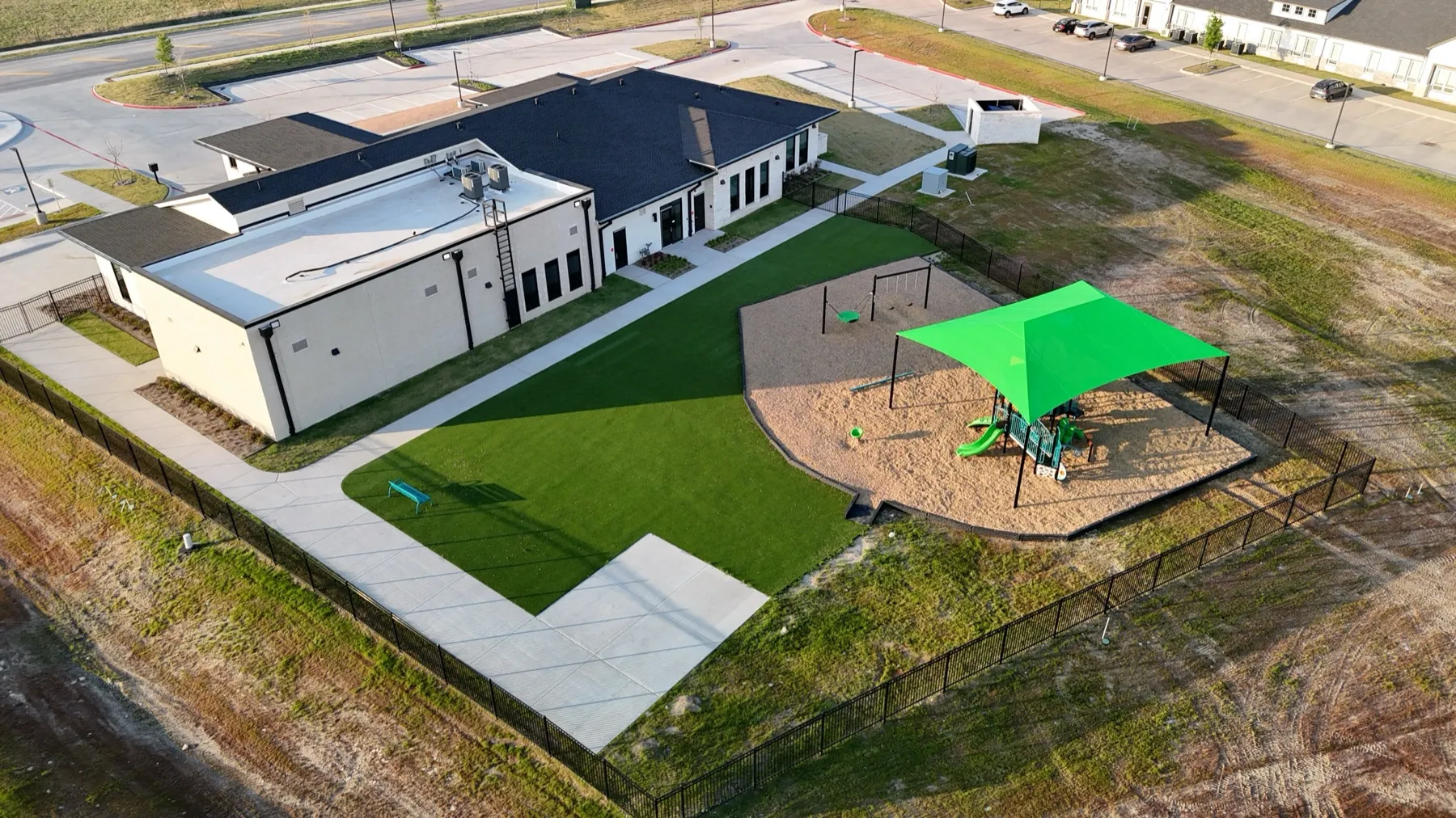 Commercial artificial turf play area with shade sail at Aledo TX school