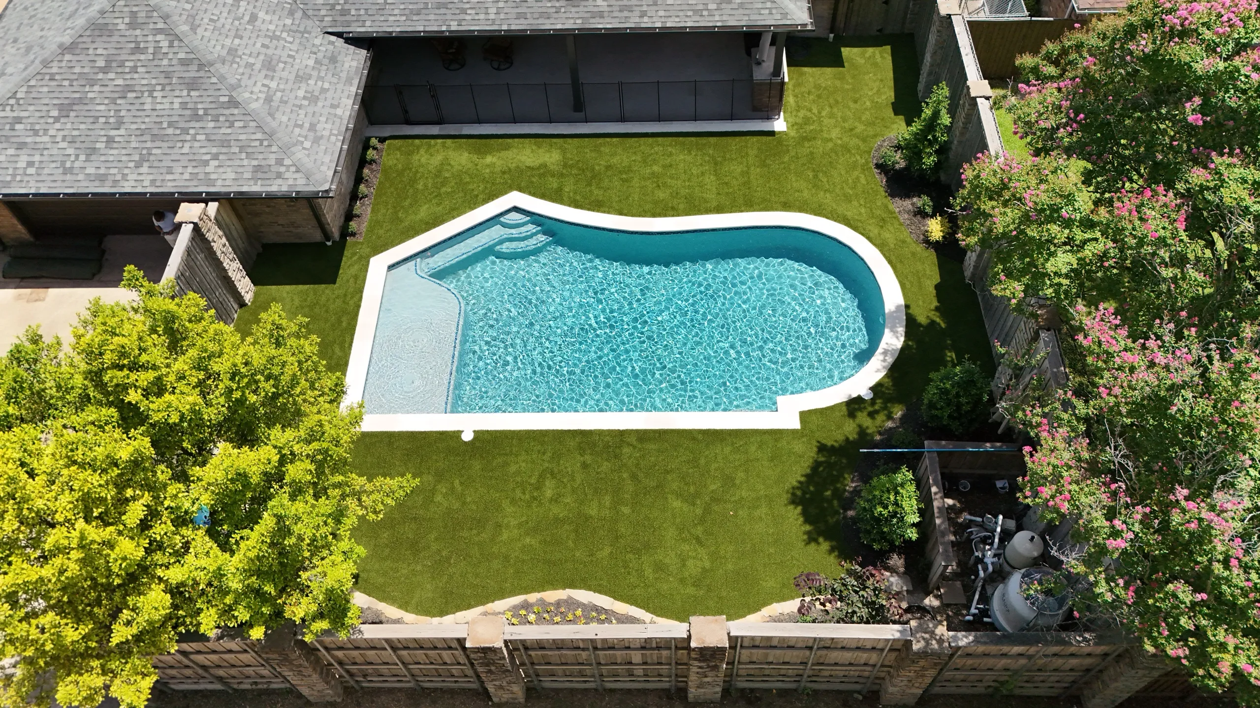 Aerial view of backyard pool with artificial turf surround in DFW