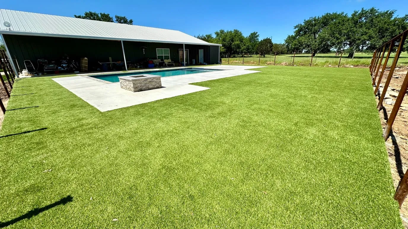 Narrow side-yard artificial turf beneath shade tree in DFW