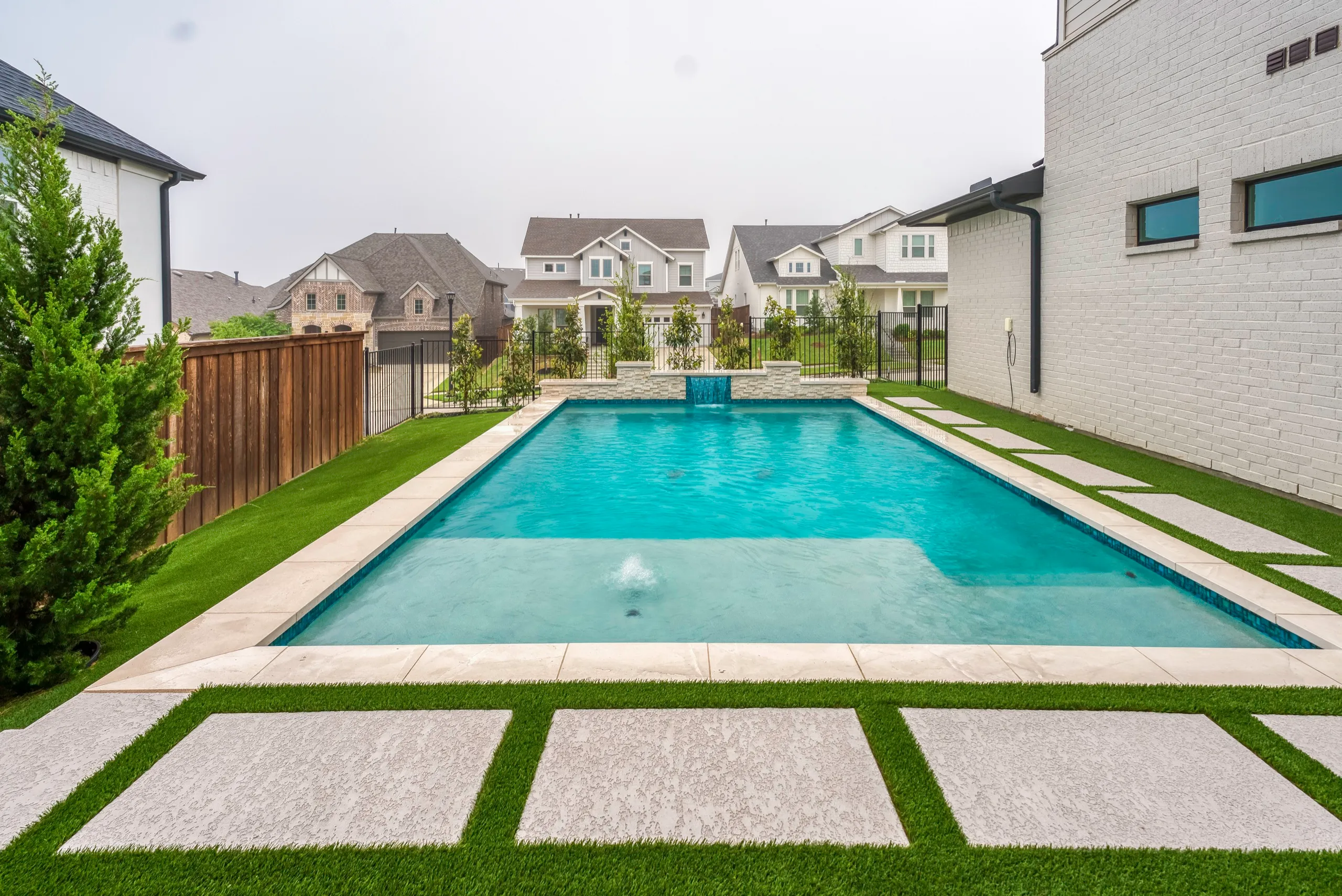 Modern backyard pool with artificial turf in North Texas