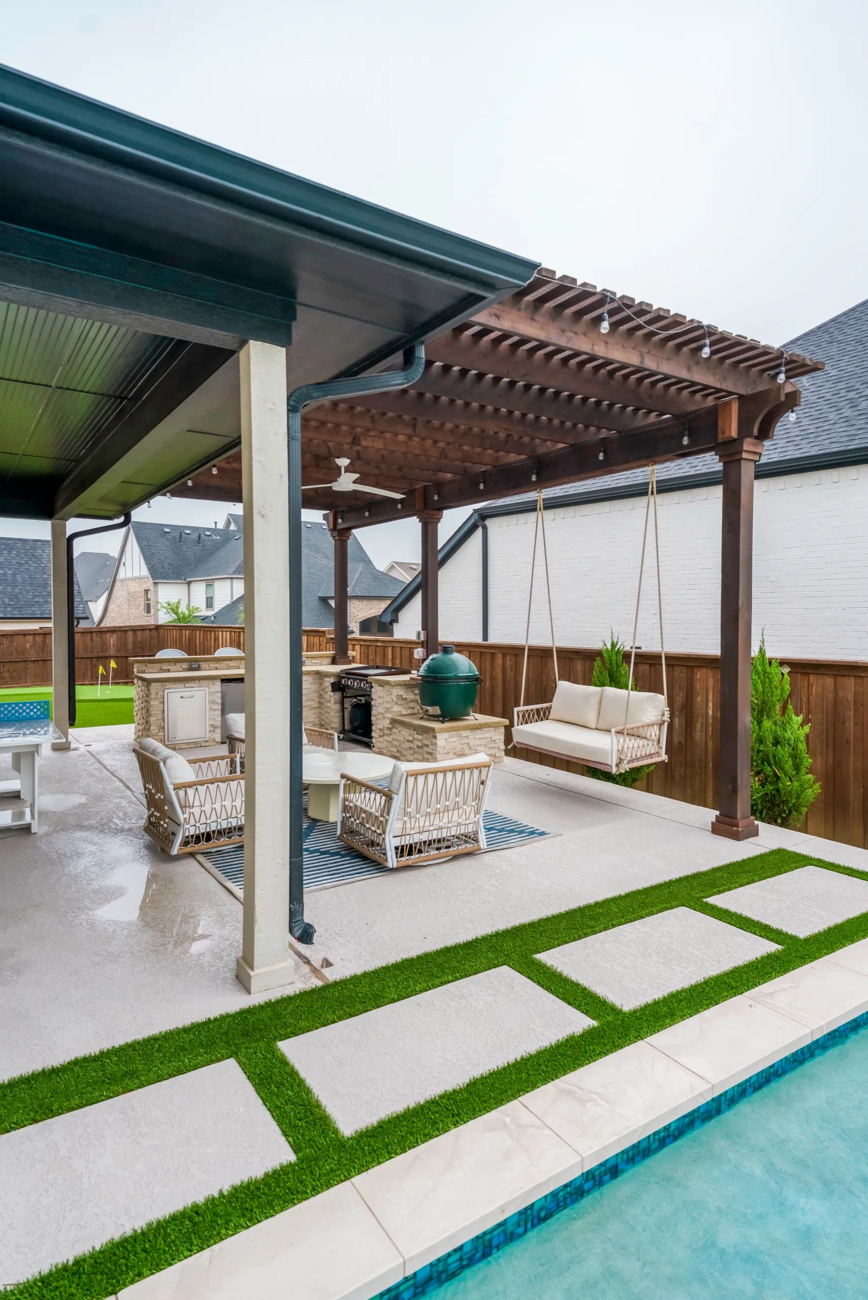 Outdoor living area with pergola and turf-and-paver strips