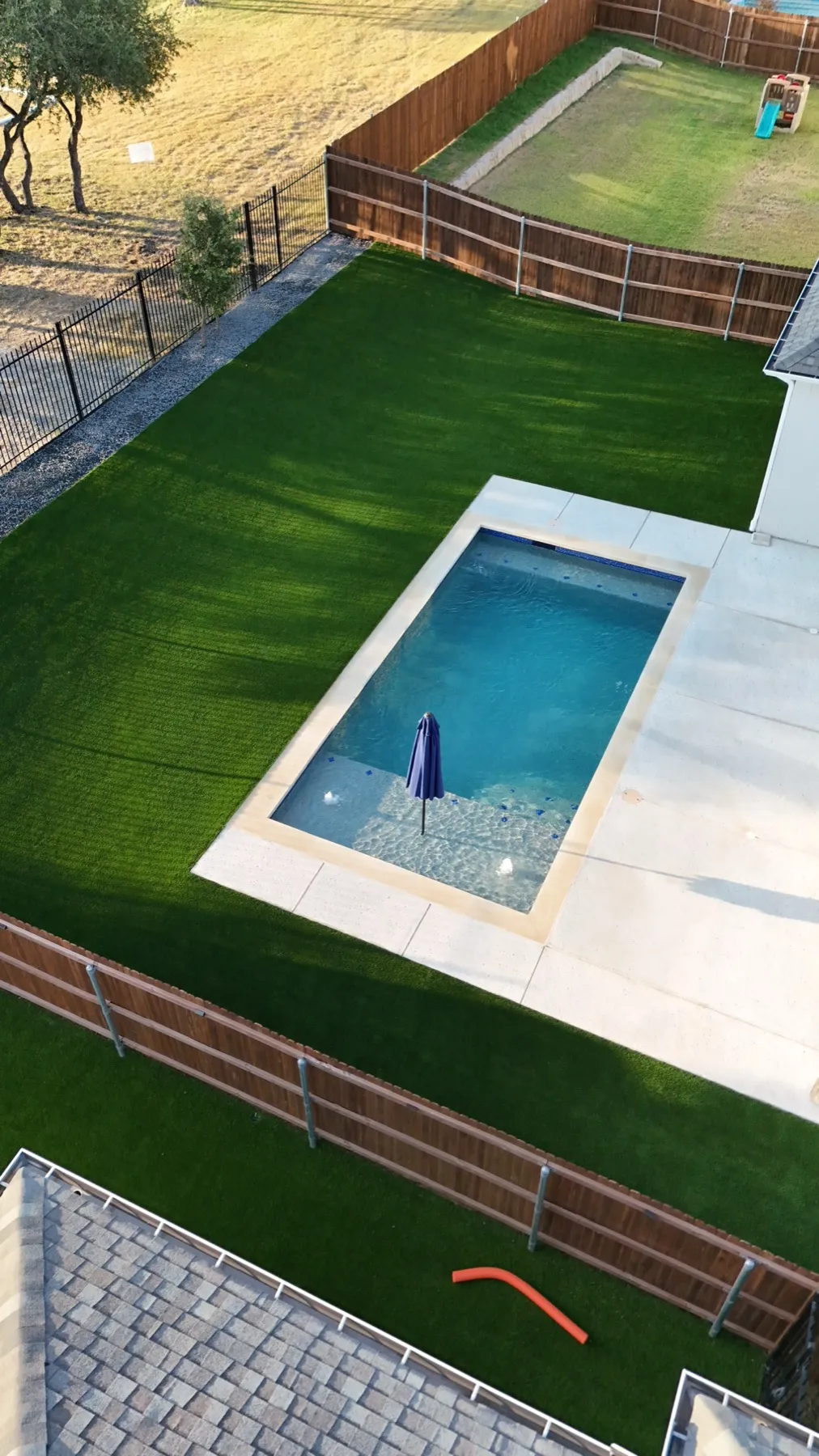 Top-down view of Aledo TX backyard pool surrounded by artificial turf