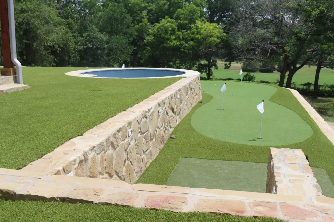 Backyard pool with artificial turf and striped lounger in DFW