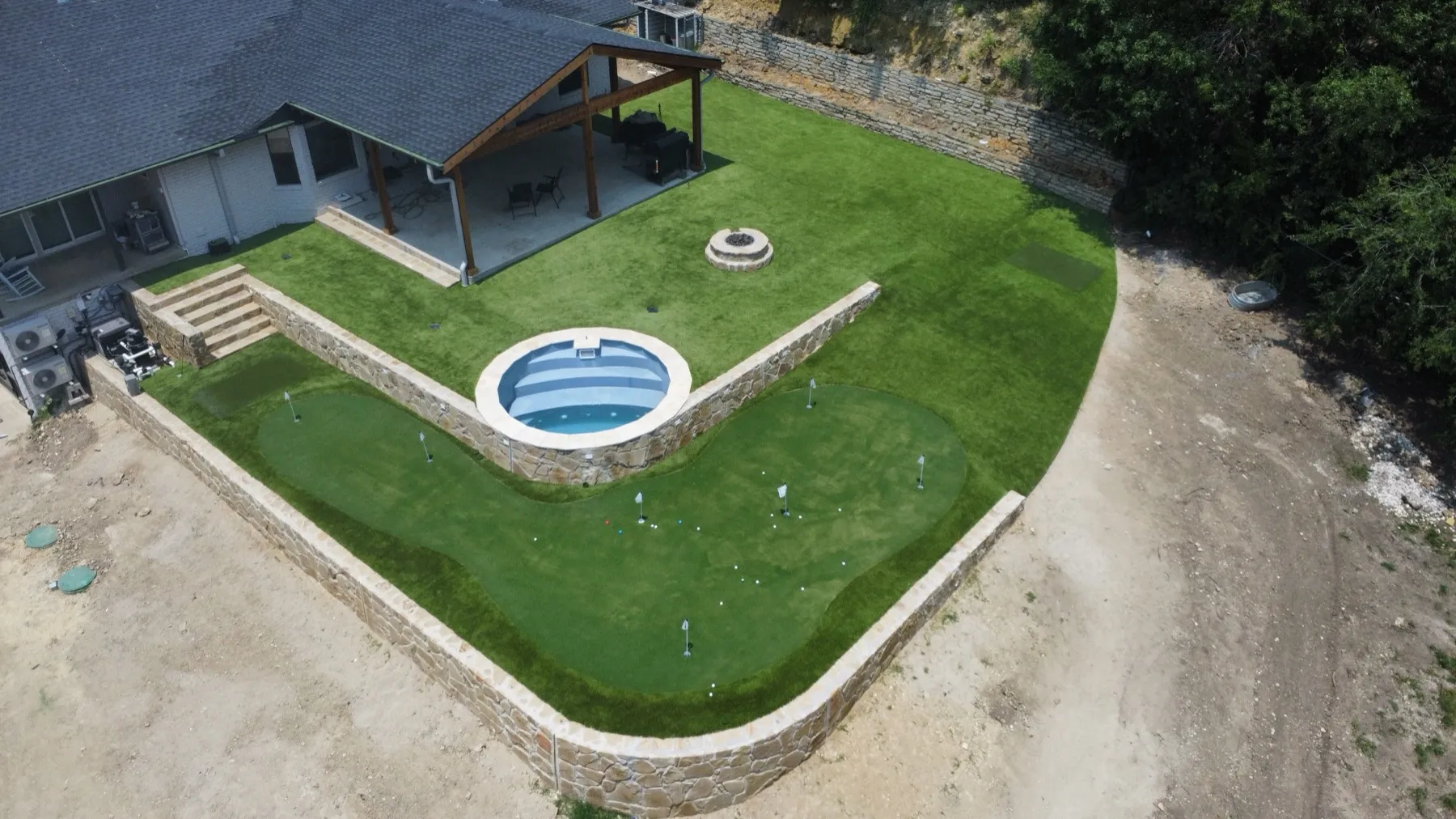Aerial backyard putting green with stock-tank pool