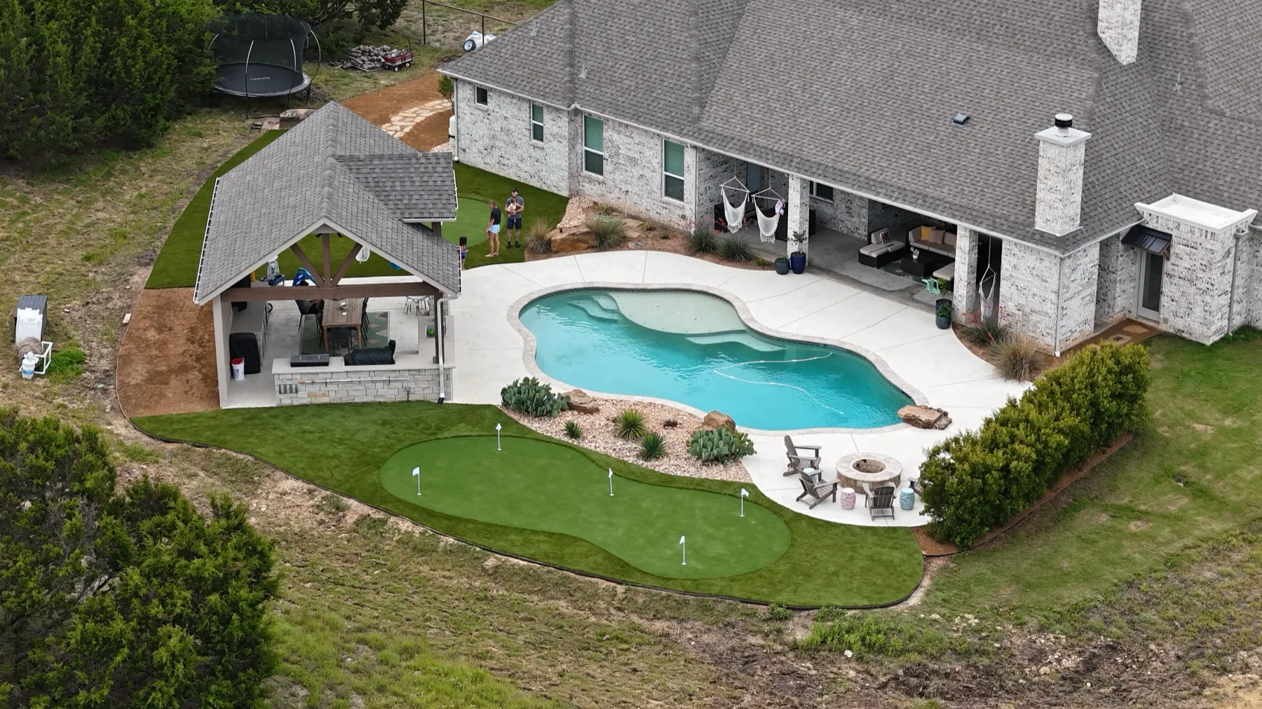 Aerial backyard pool with artificial putting green in Aledo