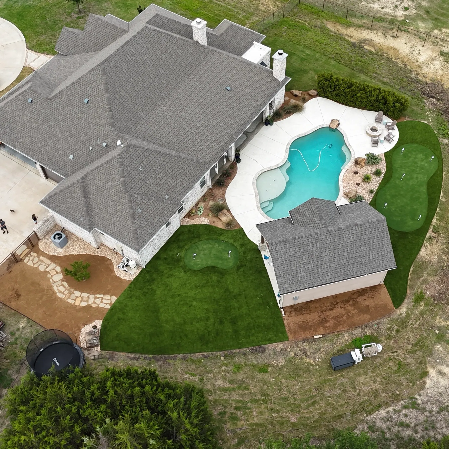 Aerial top-down of backyard pool, turf, and putting green in Aledo