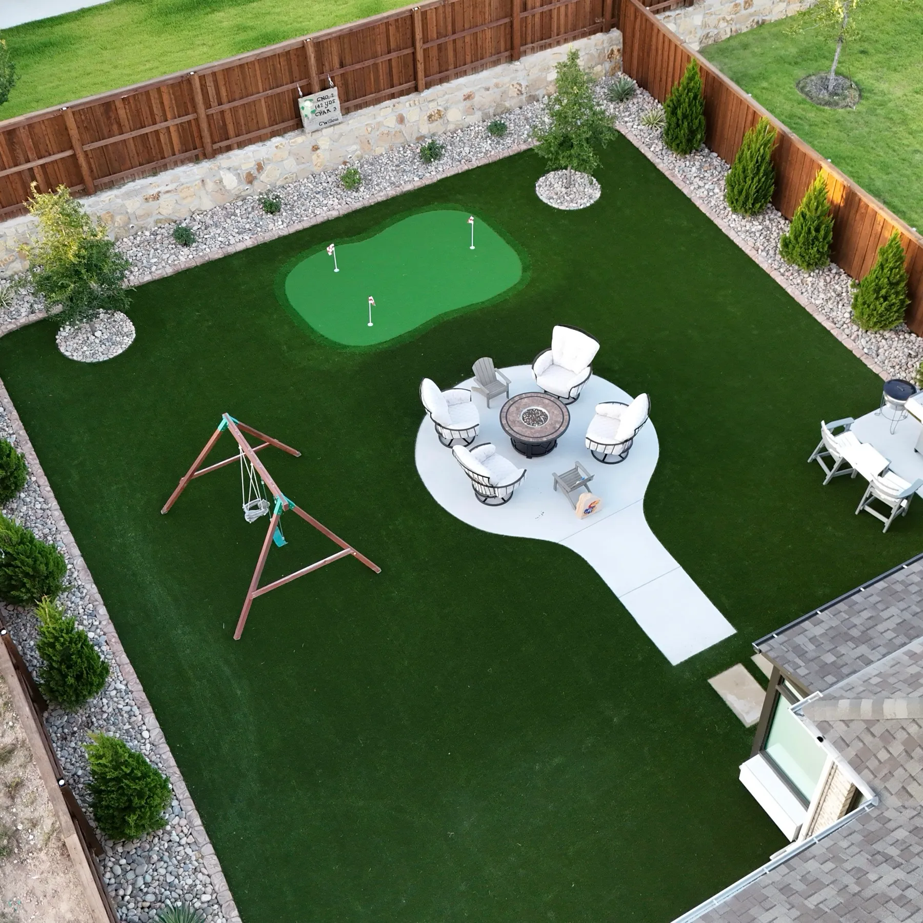 Aerial top-down backyard with putting green and firepit lounge in Aledo