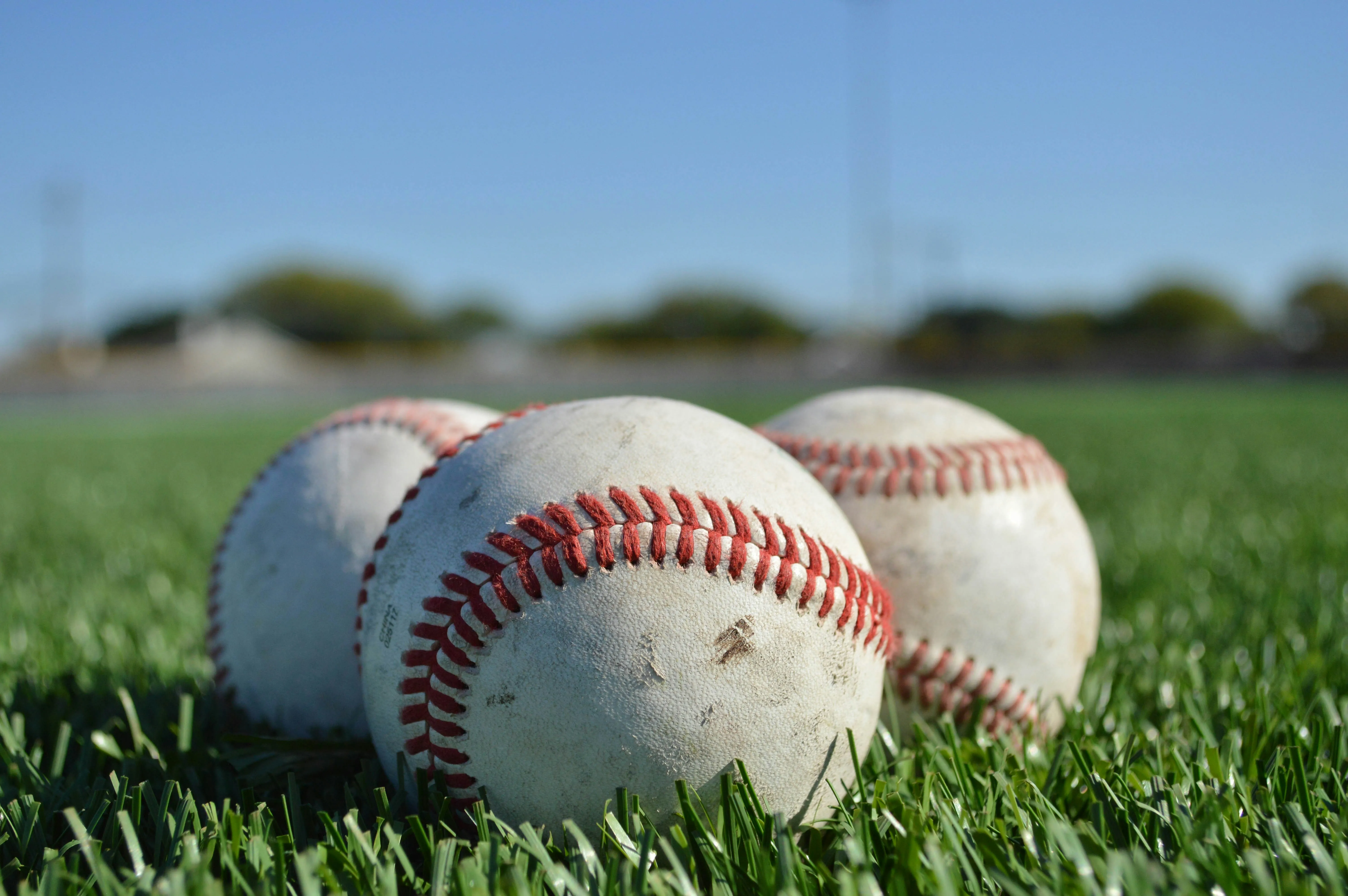 Baseballs resting on artificial turf at a youth baseball field