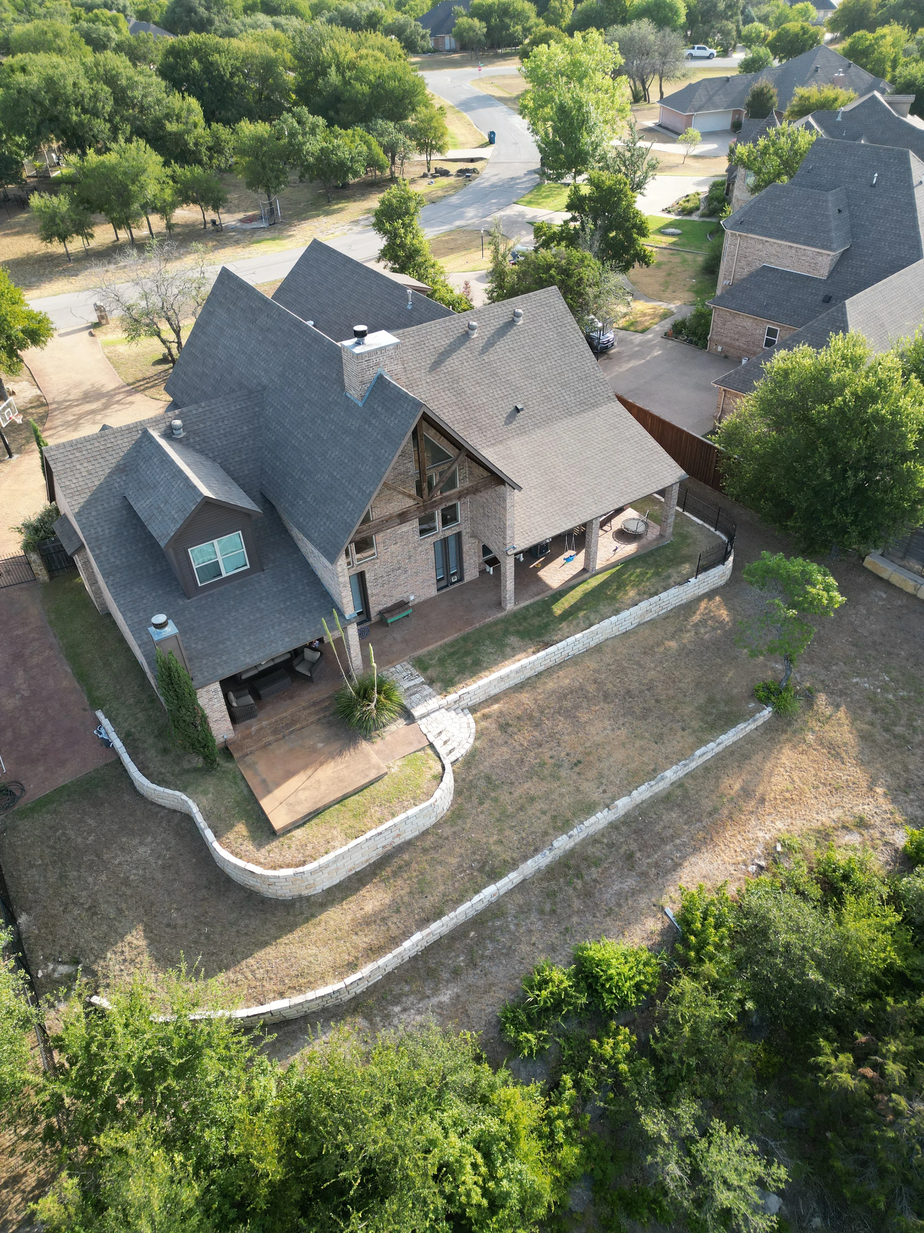 Before 2 — Aledo tiered backyard build: 606 SF Millsap retaining wall + 5,600 SF Bermuda Pro turf
