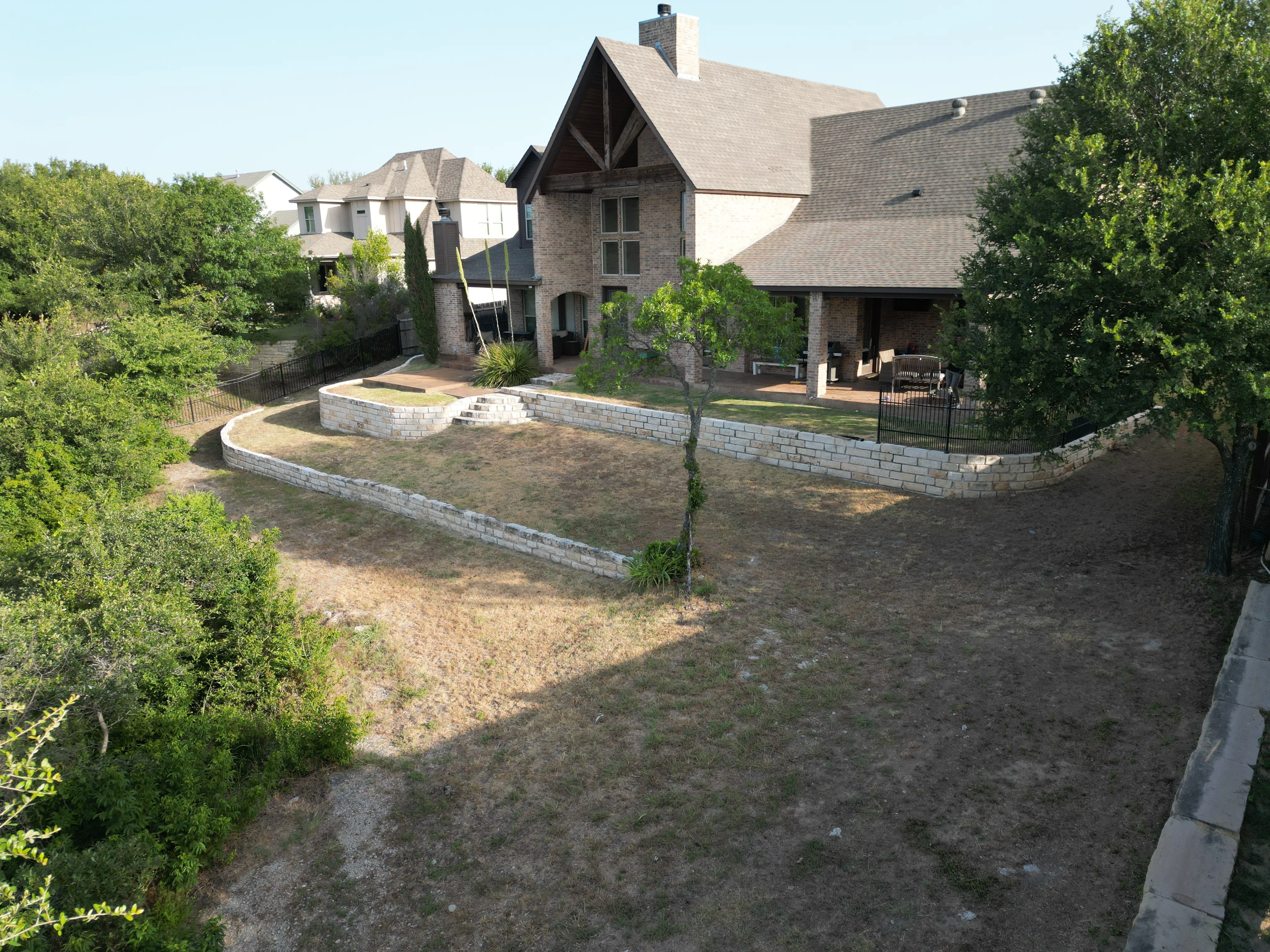 Before 4 — Aledo tiered backyard build: 606 SF Millsap retaining wall + 5,600 SF Bermuda Pro turf