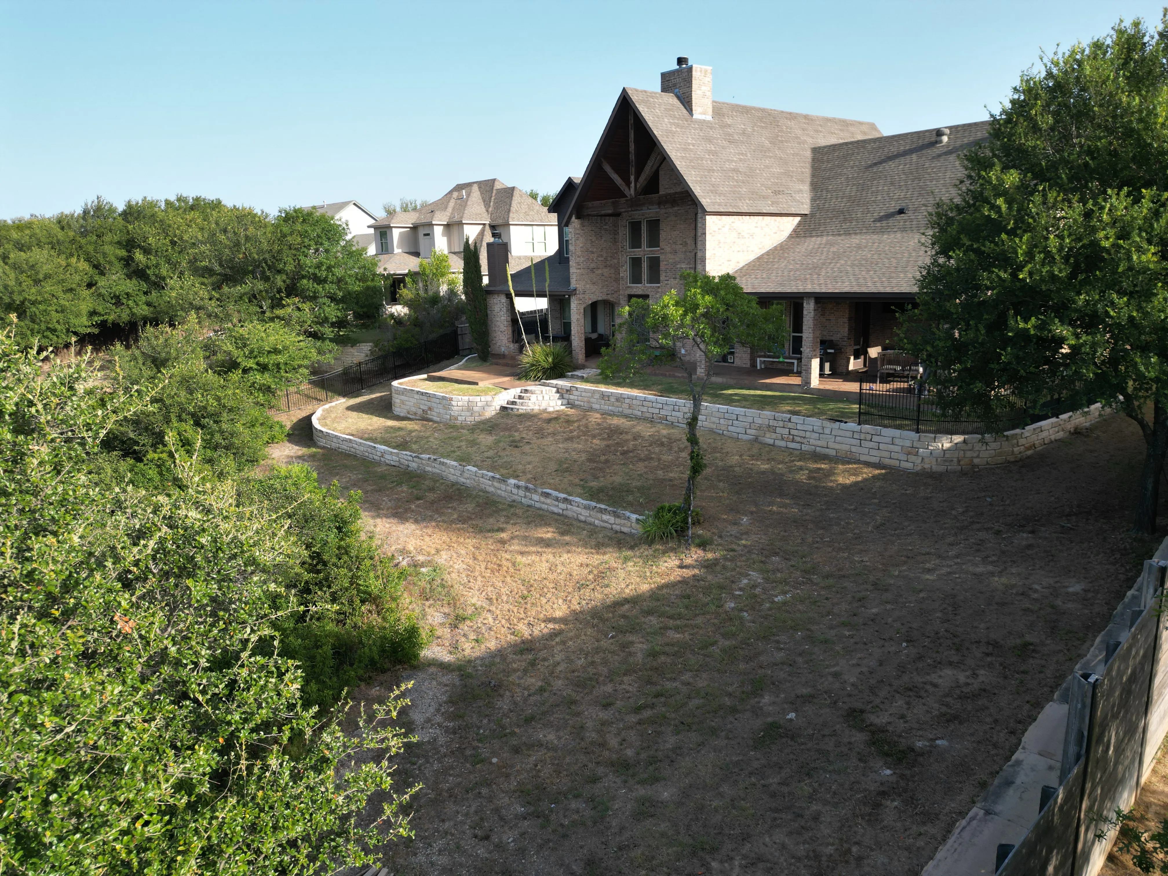Before 5 — Aledo tiered backyard build: 606 SF Millsap retaining wall + 5,600 SF Bermuda Pro turf