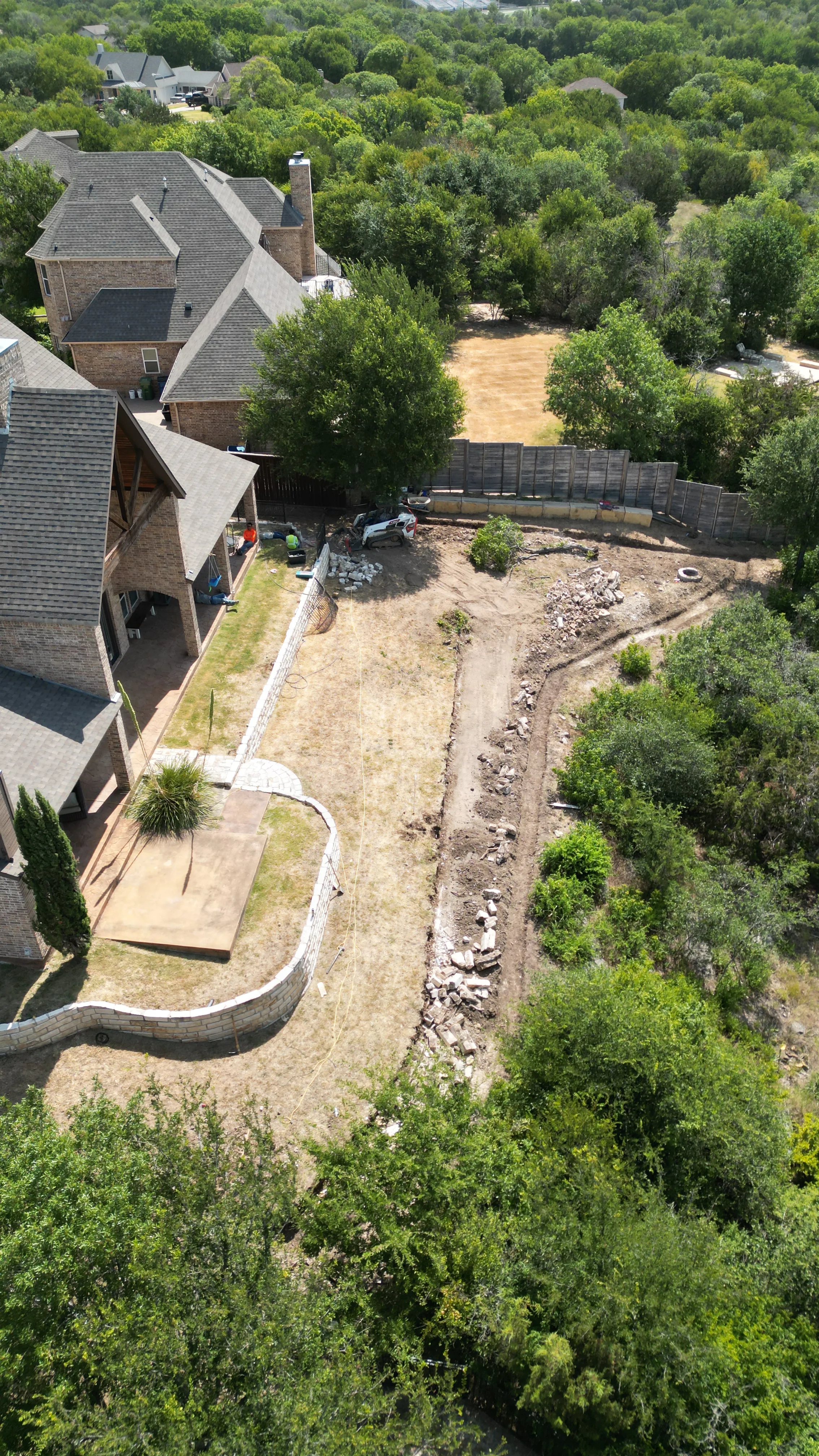 Construction 1 — Aledo tiered backyard build: 606 SF Millsap retaining wall + 5,600 SF Bermuda Pro turf