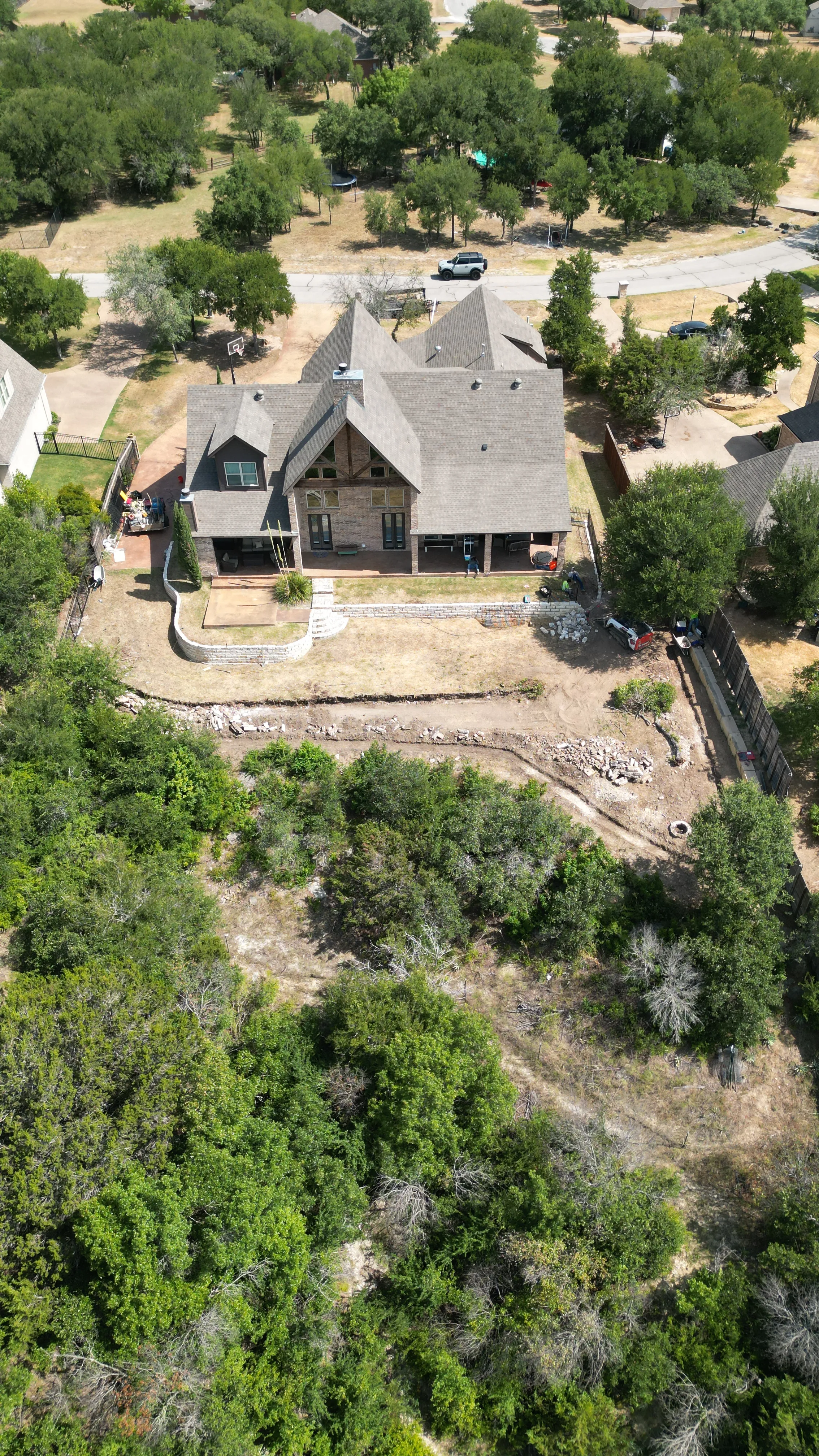 Construction 2 — Aledo tiered backyard build: 606 SF Millsap retaining wall + 5,600 SF Bermuda Pro turf