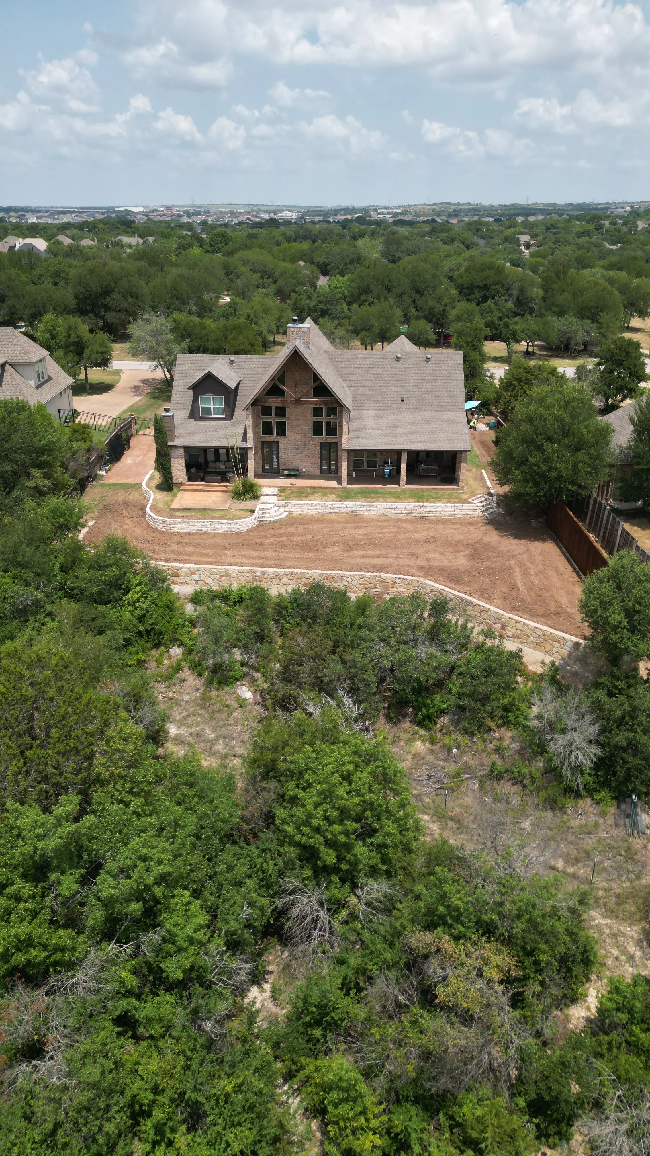 Construction 9 — Aledo tiered backyard build: 606 SF Millsap retaining wall + 5,600 SF Bermuda Pro turf