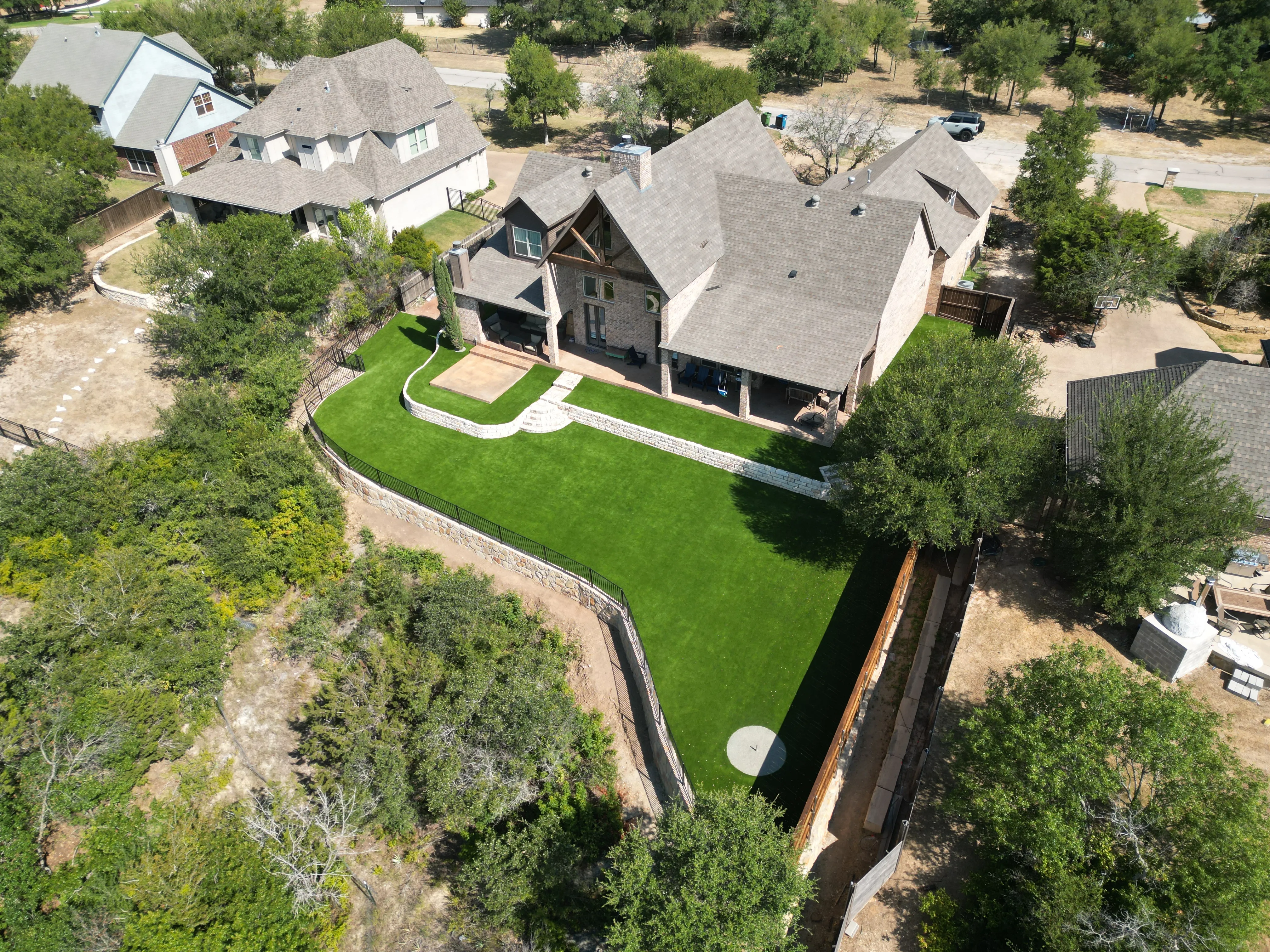 Aledo tiered backyard build: 606 SF Millsap retaining wall + 5,600 SF Bermuda Pro turf feature 3