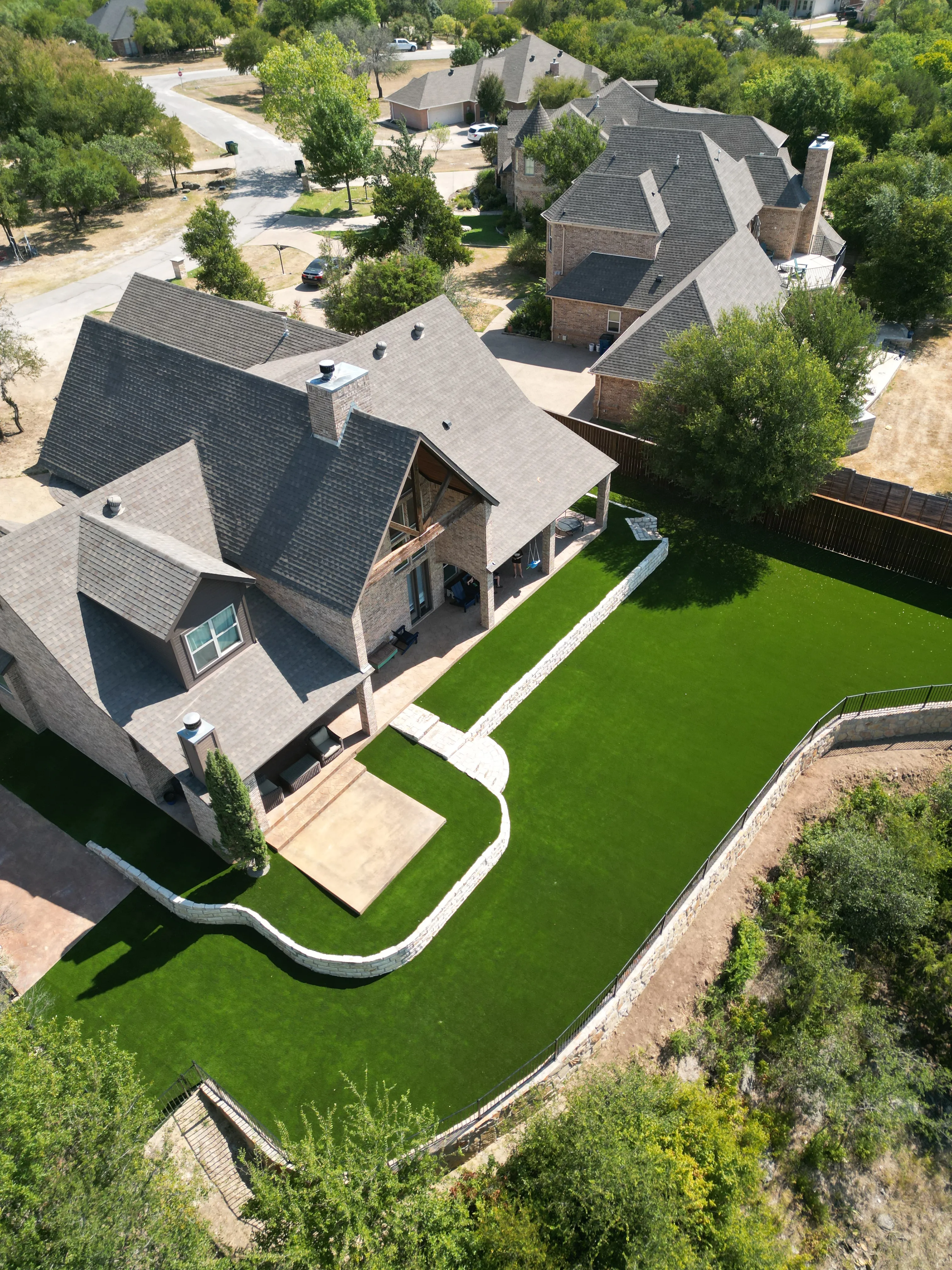 After 4 — Aledo tiered backyard build: 606 SF Millsap retaining wall + 5,600 SF Bermuda Pro turf