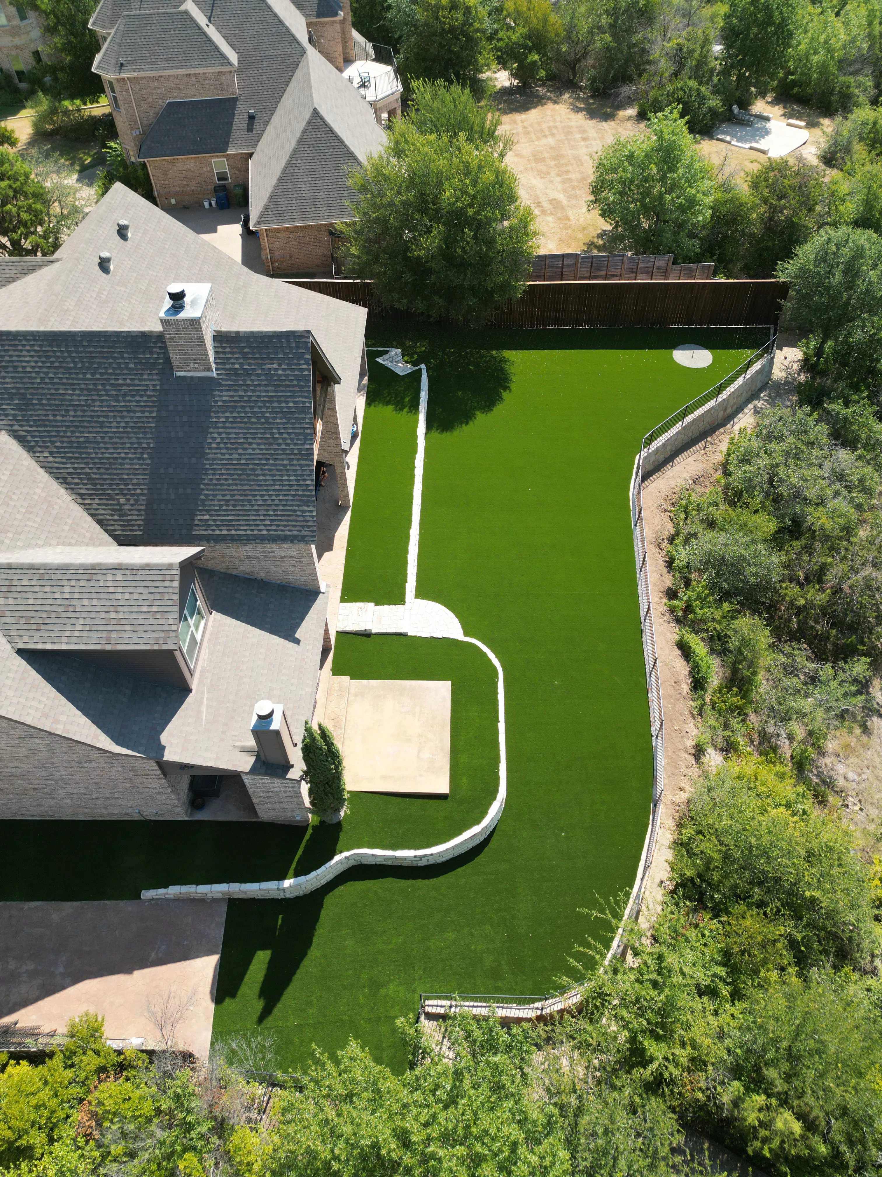 After 6 — Aledo tiered backyard build: 606 SF Millsap retaining wall + 5,600 SF Bermuda Pro turf