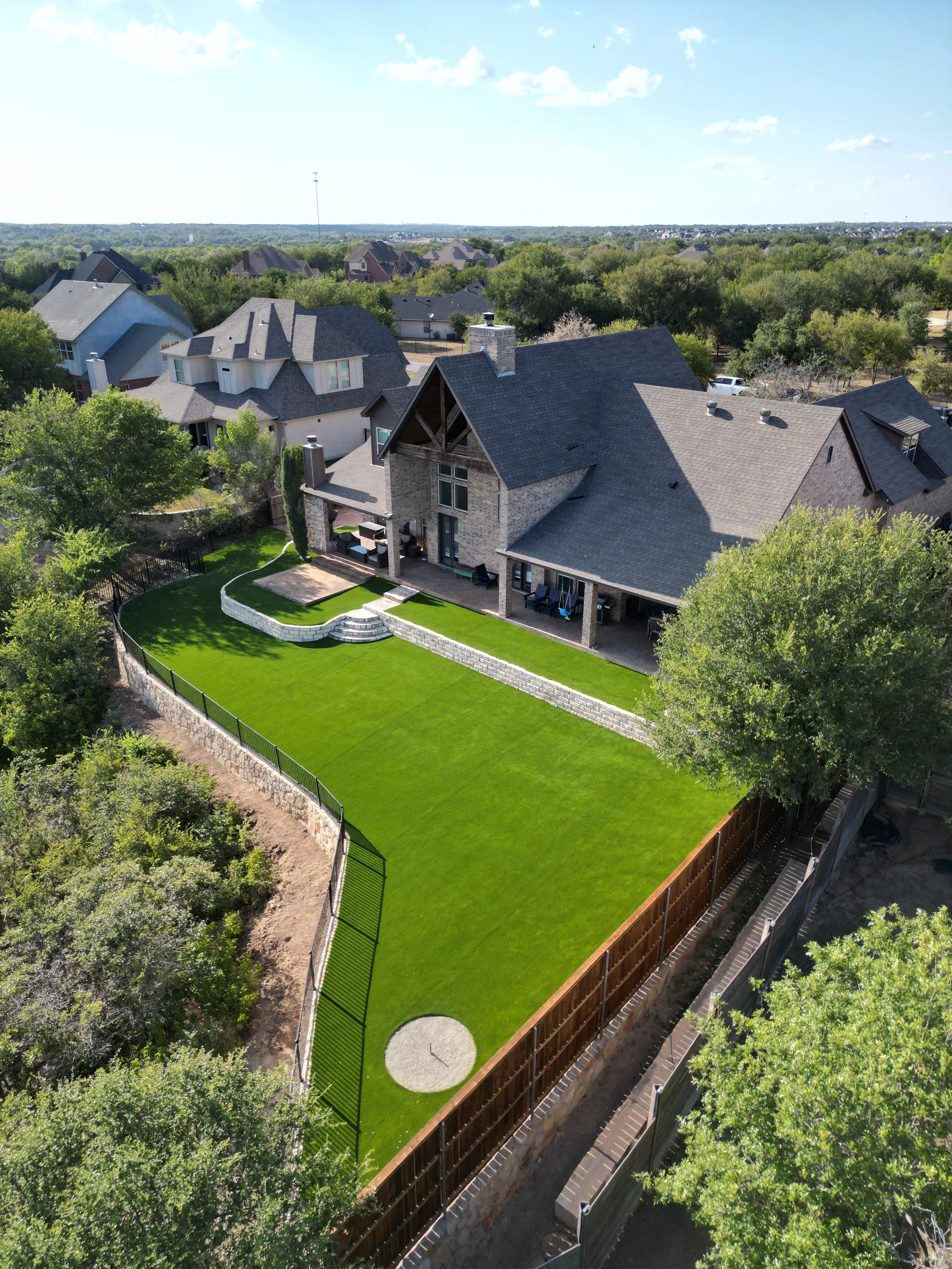 After 7 — Aledo tiered backyard build: 606 SF Millsap retaining wall + 5,600 SF Bermuda Pro turf