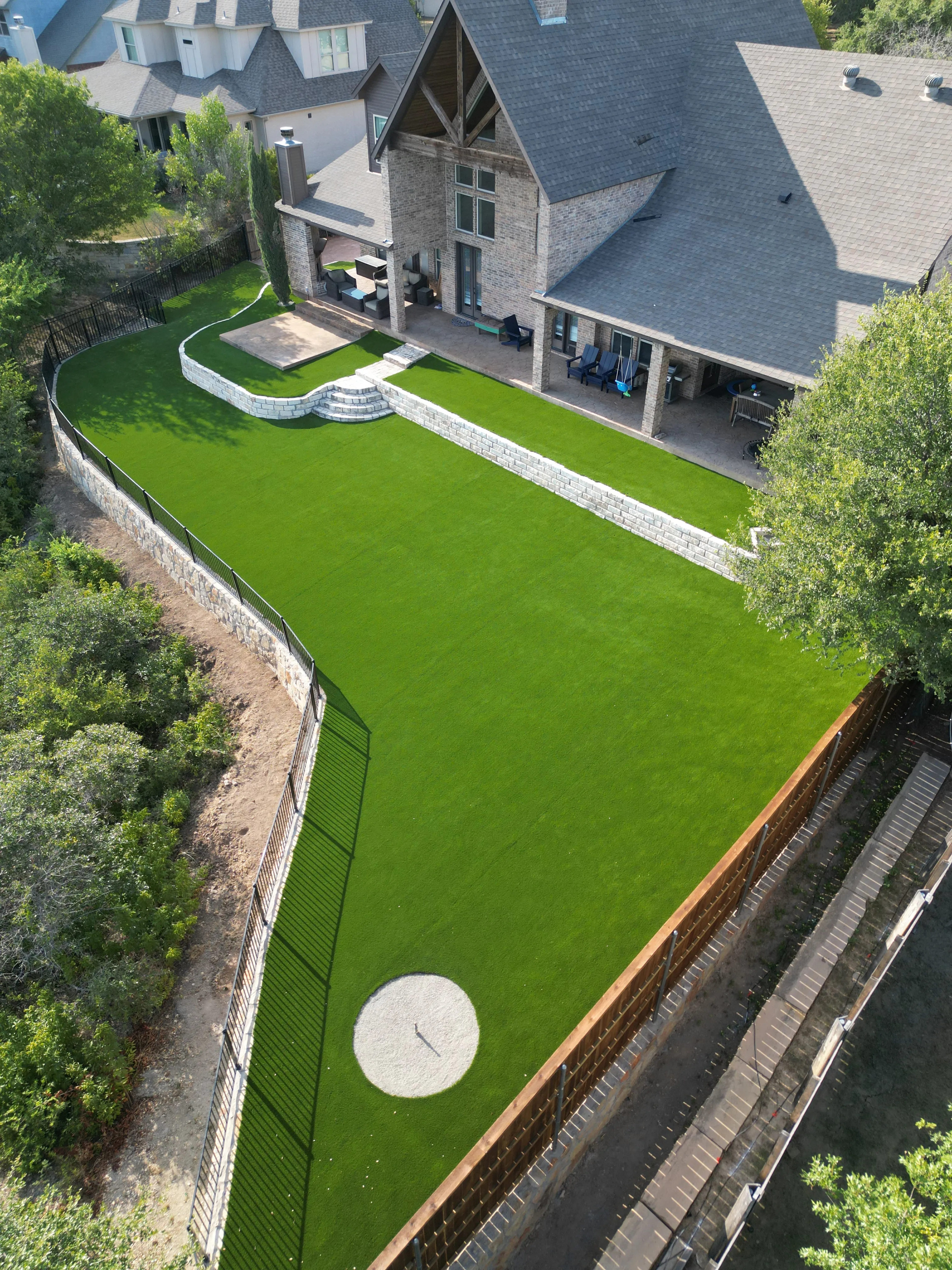 After 8 — Aledo tiered backyard build: 606 SF Millsap retaining wall + 5,600 SF Bermuda Pro turf