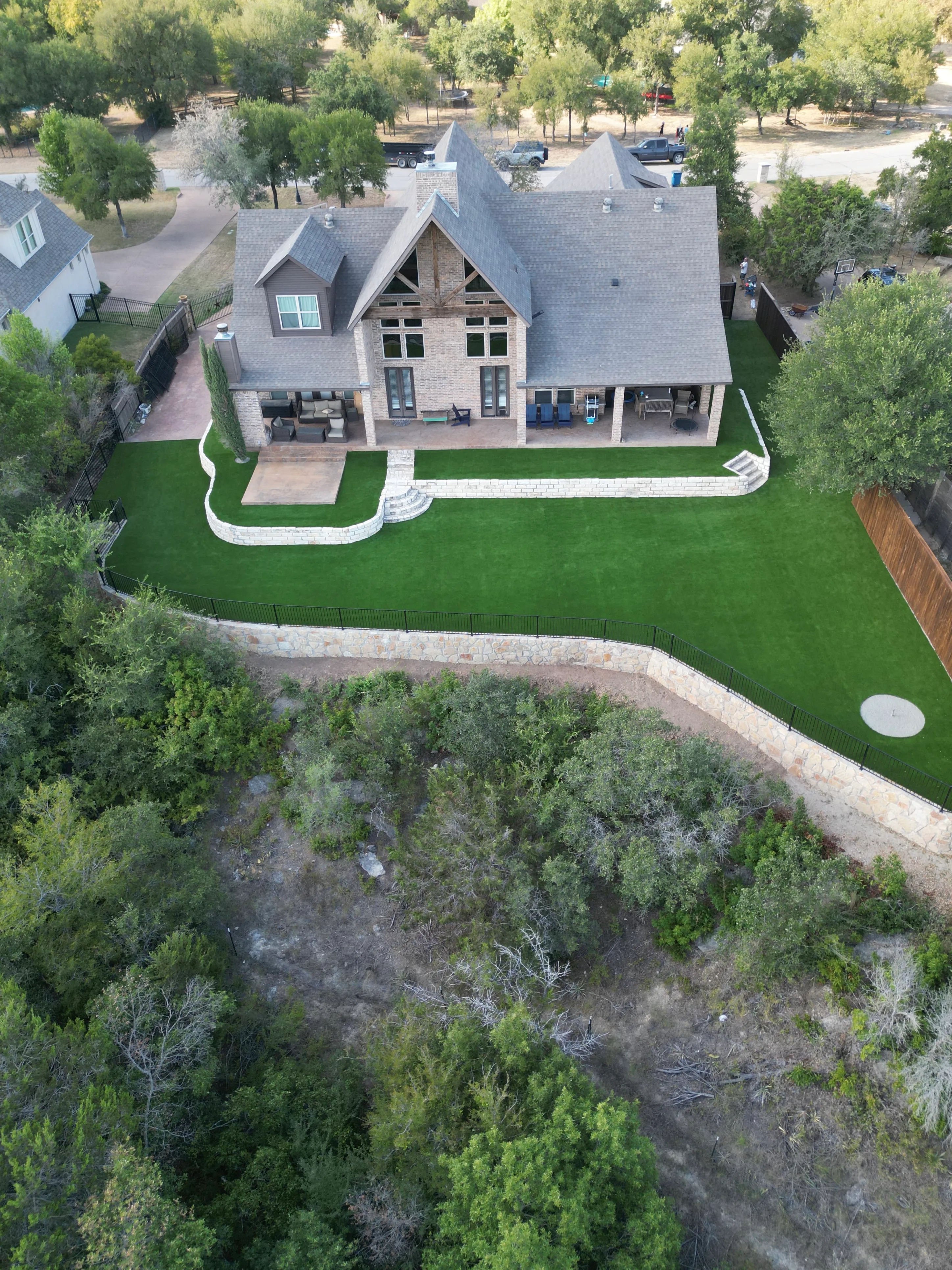 After 9 — Aledo tiered backyard build: 606 SF Millsap retaining wall + 5,600 SF Bermuda Pro turf