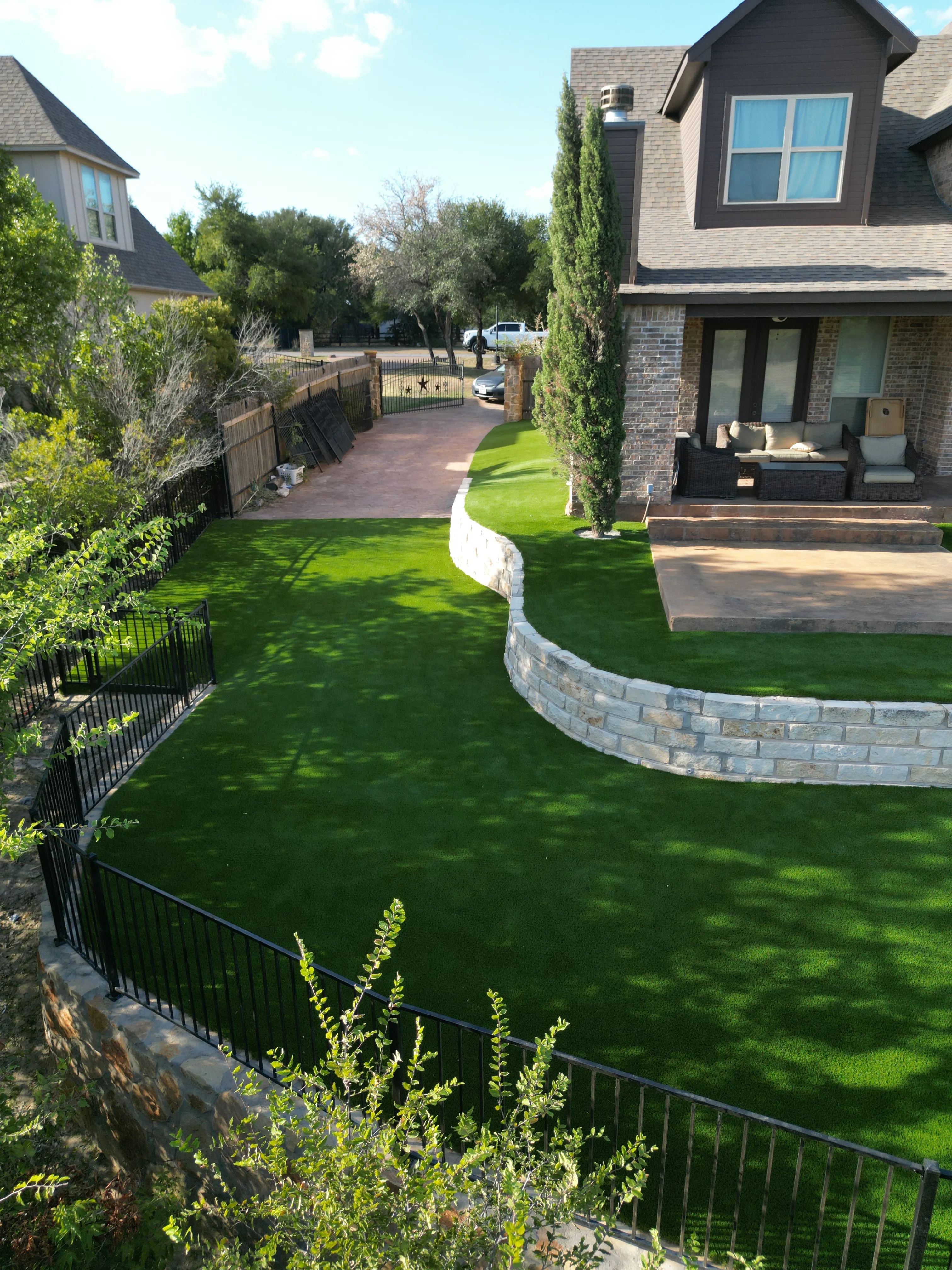After 13 — Aledo tiered backyard build: 606 SF Millsap retaining wall + 5,600 SF Bermuda Pro turf
