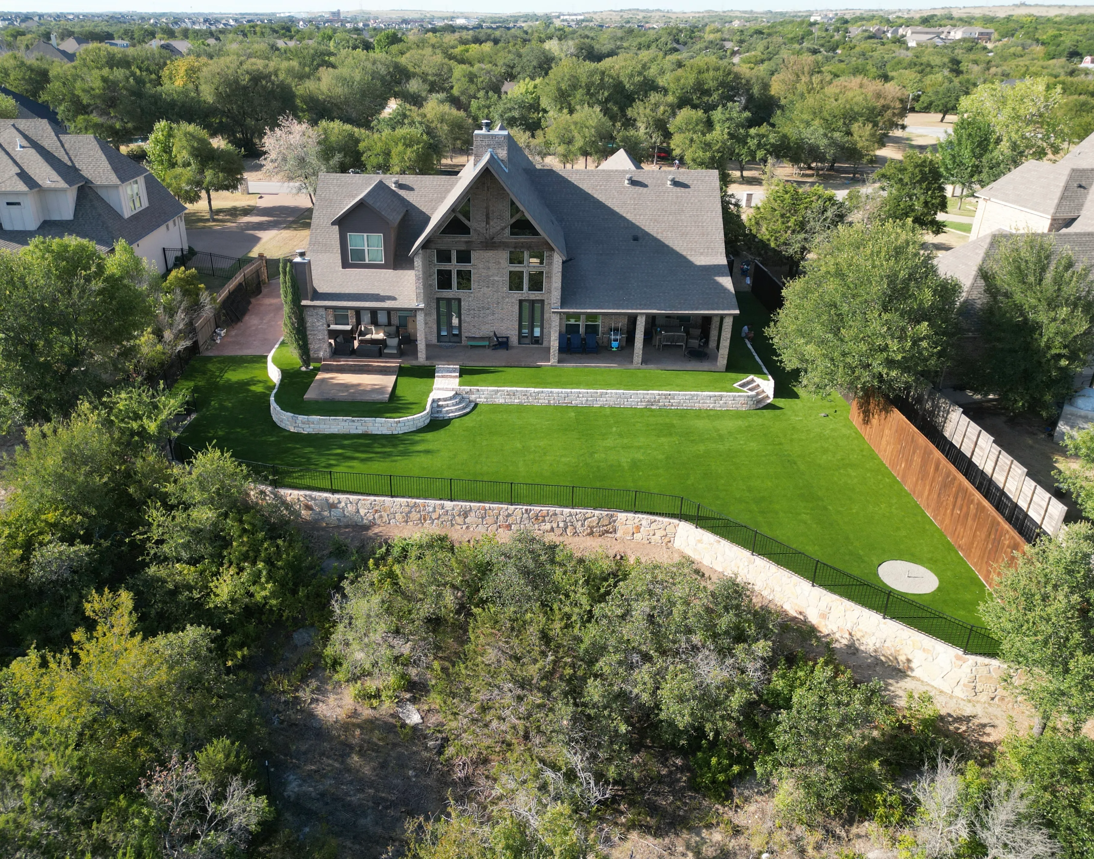 After 15 — Aledo tiered backyard build: 606 SF Millsap retaining wall + 5,600 SF Bermuda Pro turf
