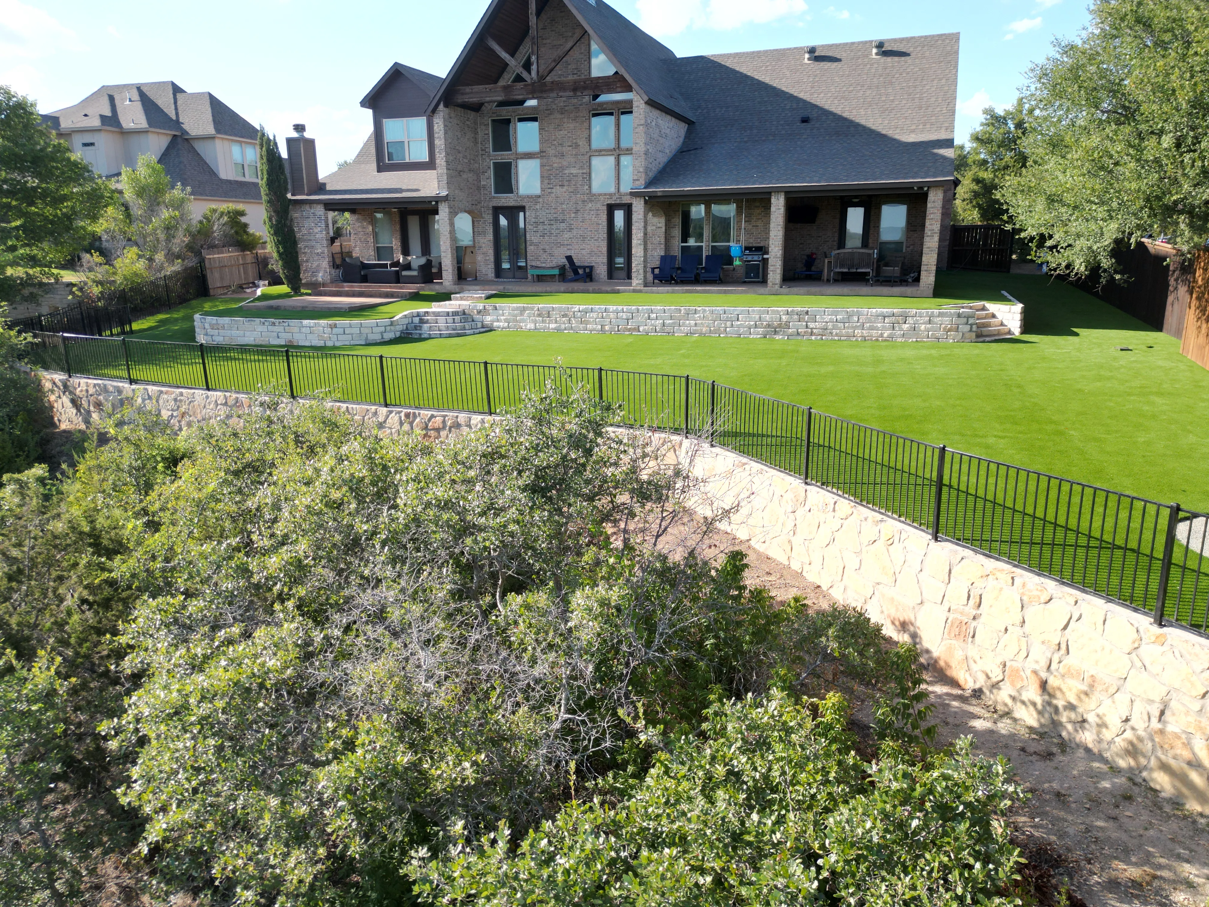 After 17 — Aledo tiered backyard build: 606 SF Millsap retaining wall + 5,600 SF Bermuda Pro turf