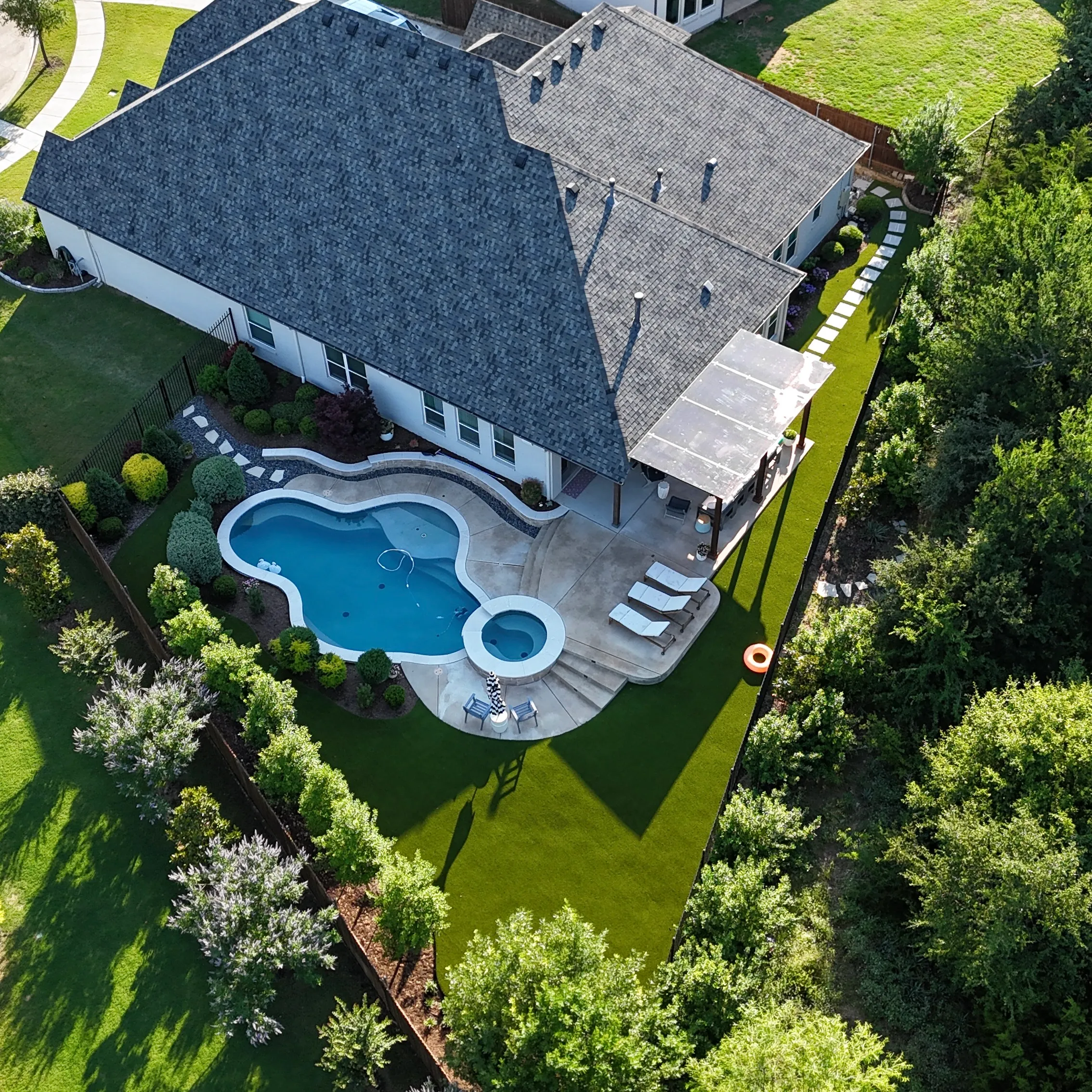 After 6 — Parks of Aledo backyard conversion: 1,750 SF of turf that disappears into the greenbelt, plus a paver walkway