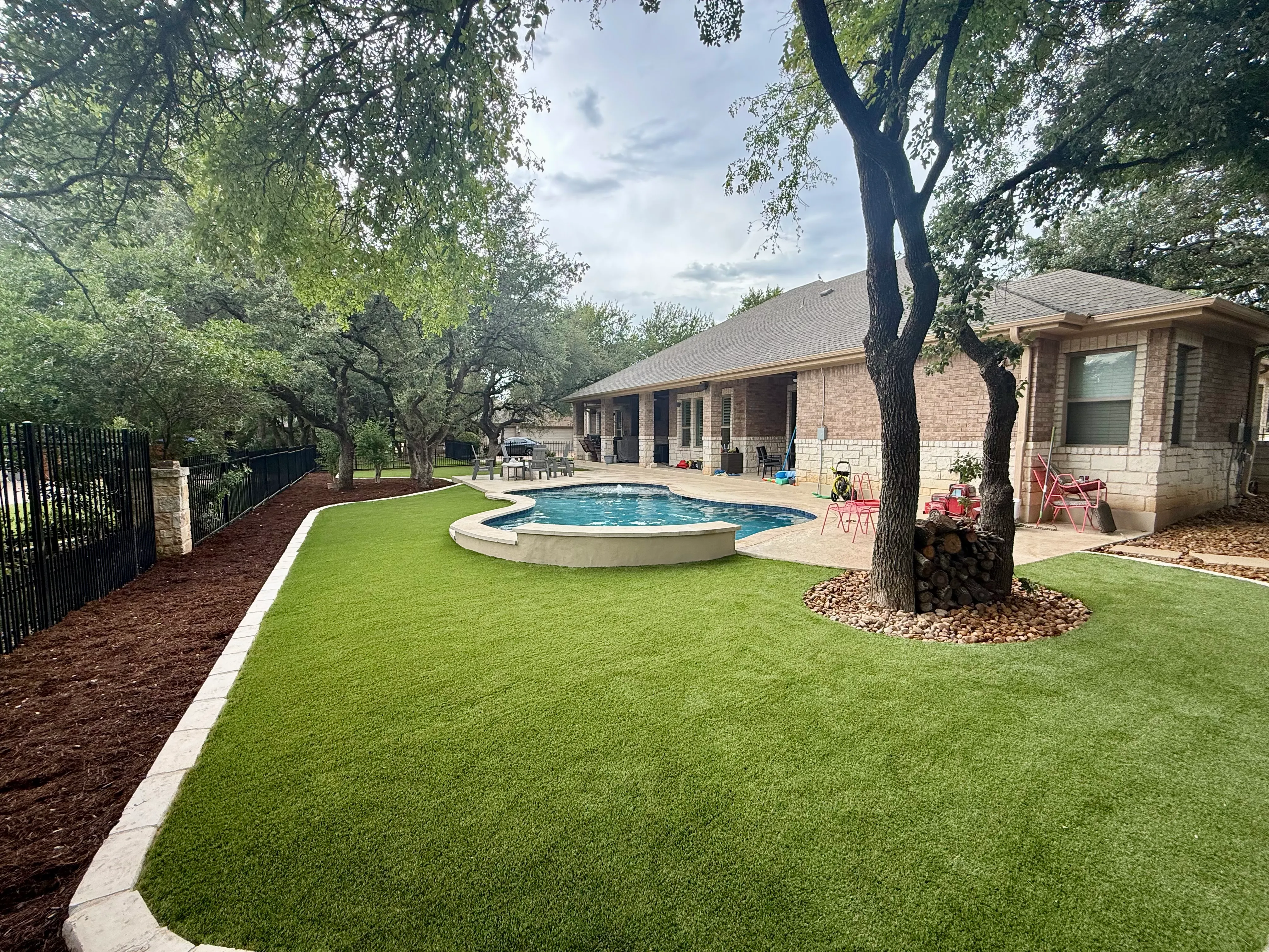 Georgetown complete backyard renovation: turf, limestone, and living space under the live oaks — after