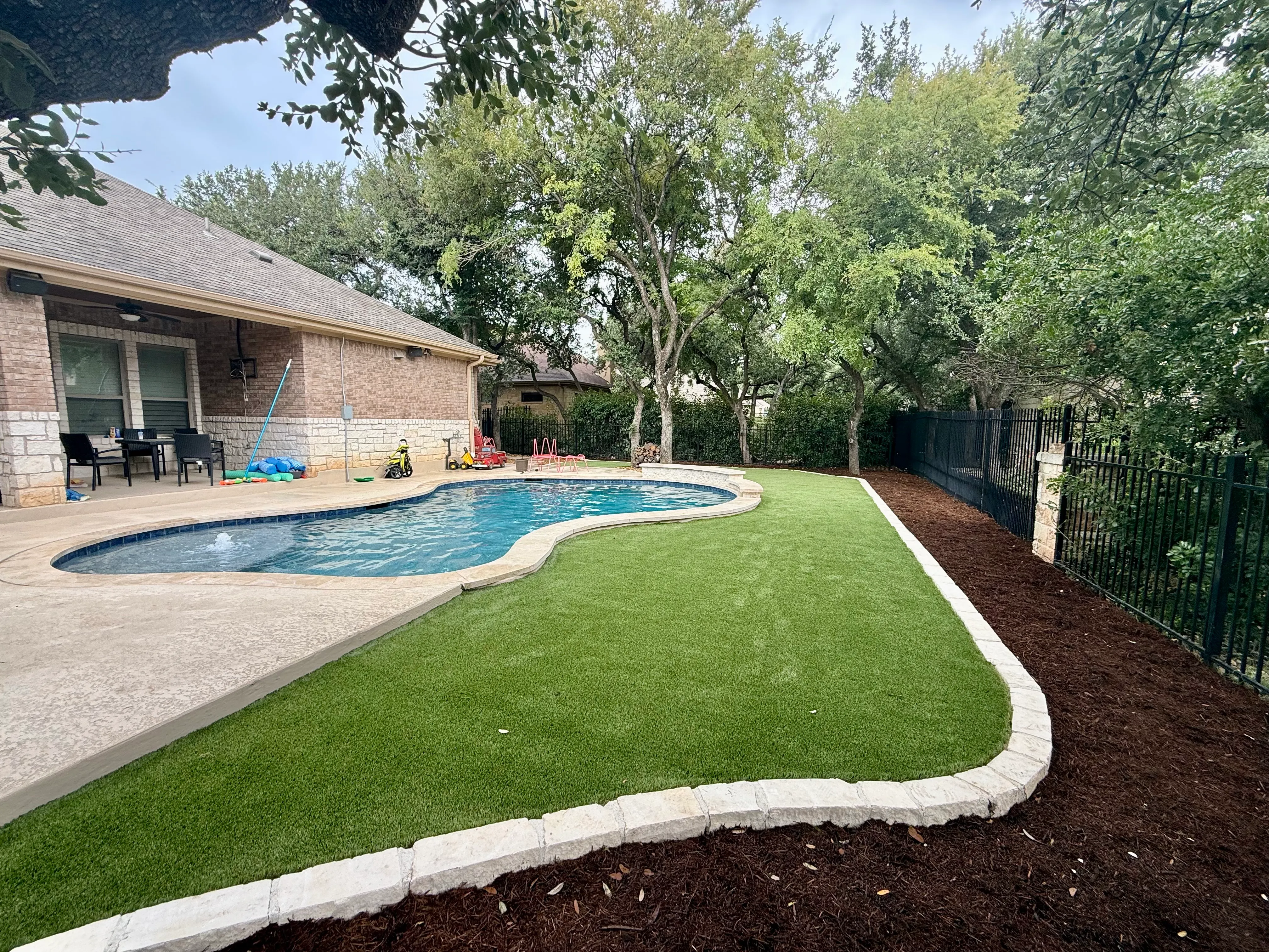 Georgetown complete backyard renovation: turf, limestone, and living space under the live oaks