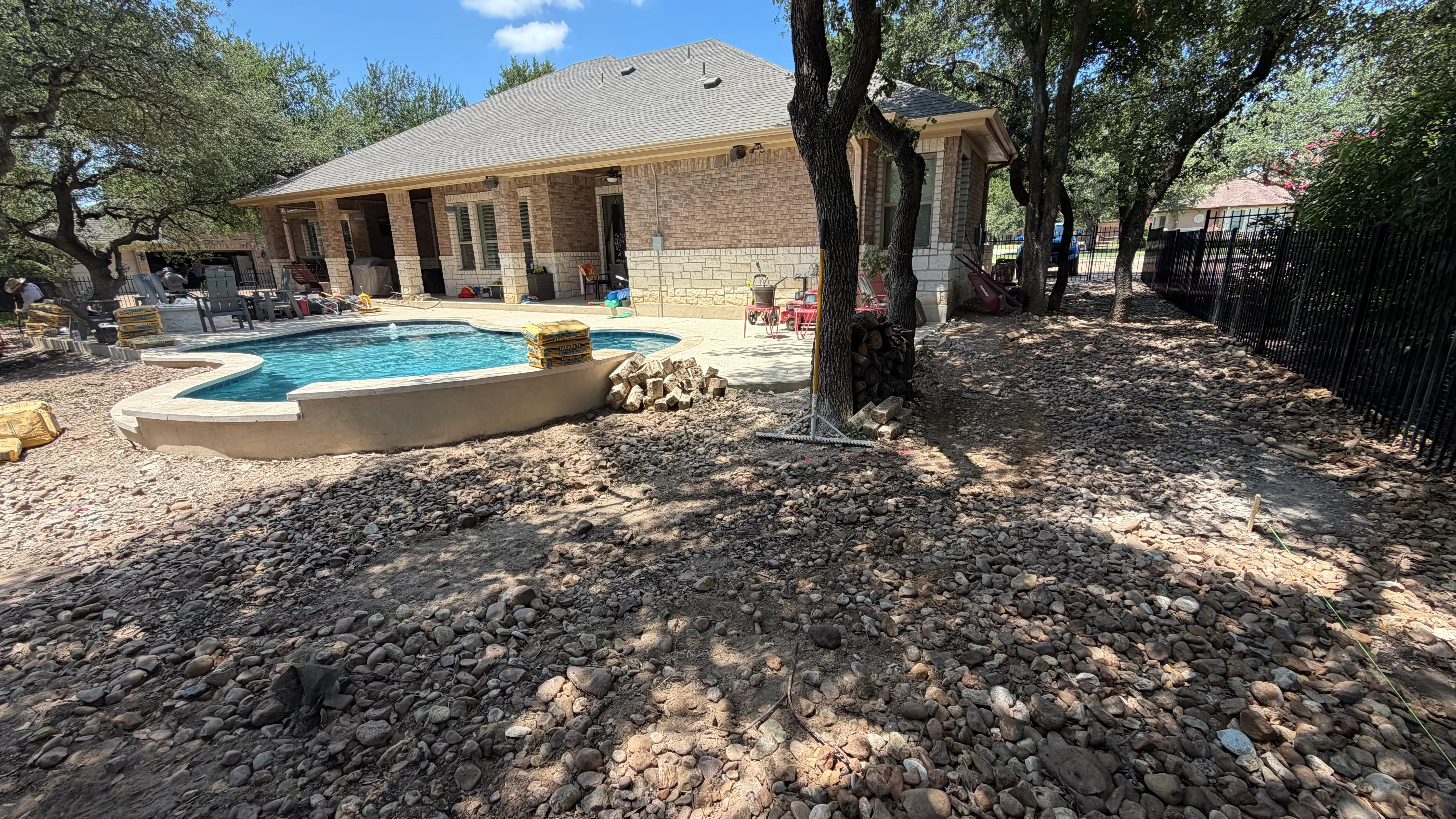 Georgetown complete backyard renovation: turf, limestone, and living space under the live oaks — before