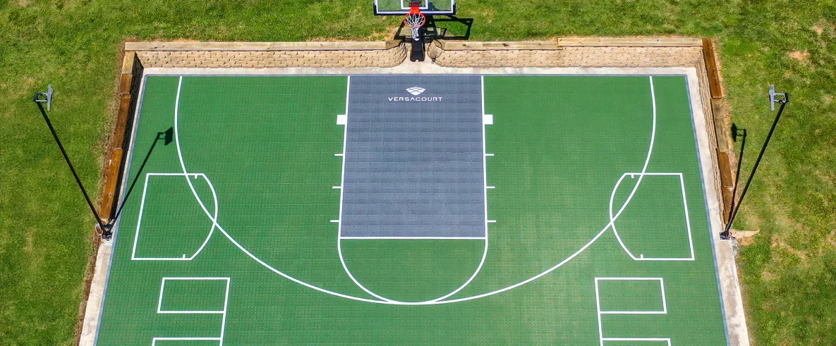 Aerial view of a VersaCourt modular tile backyard basketball court with volleyball lines