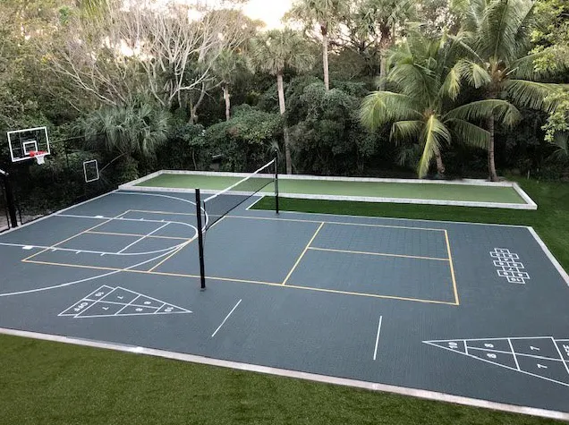 VersaCourt multi-sport tile court with a turf surround and sports lighting