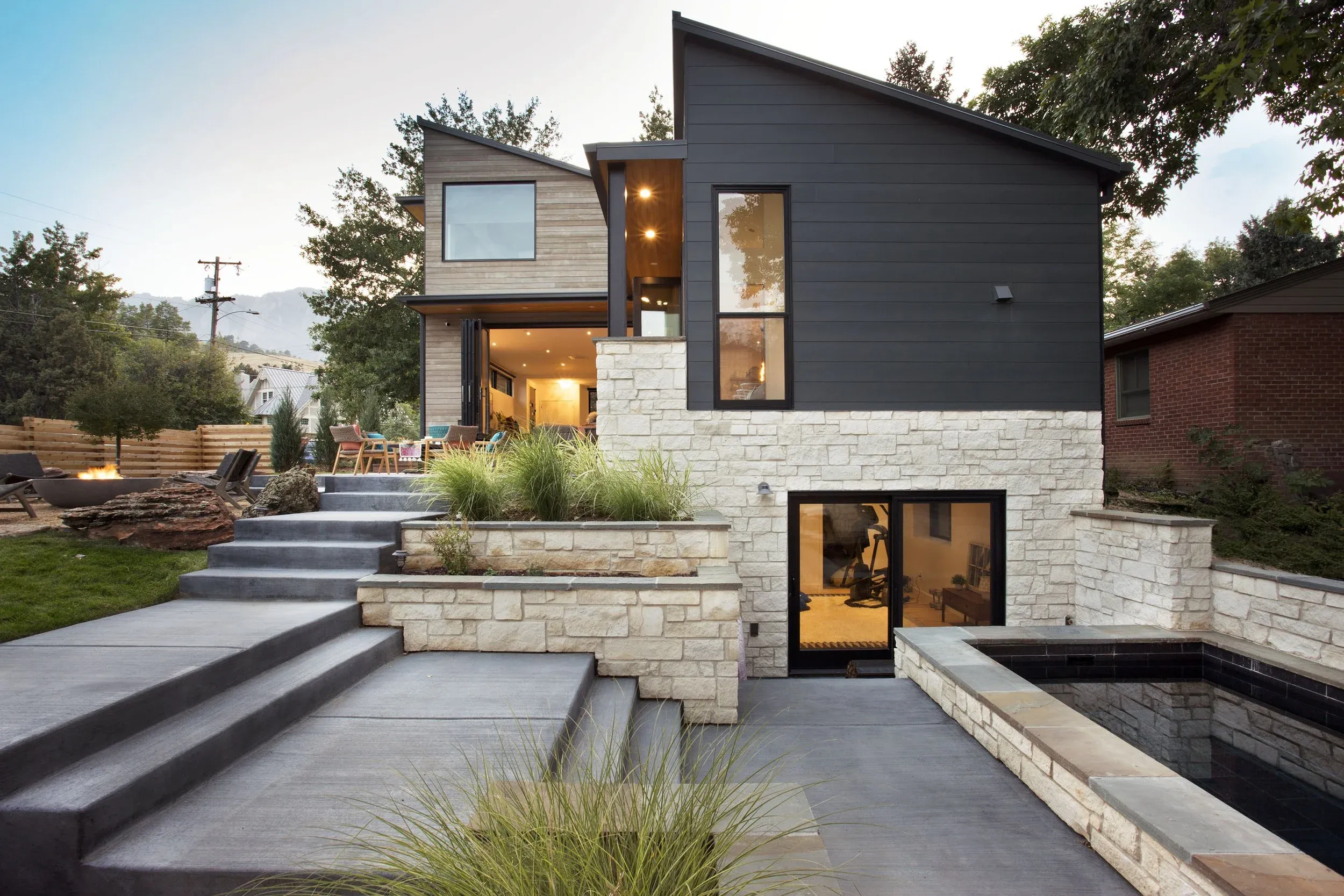 Soake plunge pool set into a tiered sloped backyard with stone retaining walls