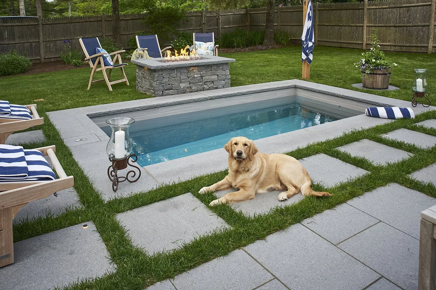 Soake precast concrete plunge pool with stone coping, turf-strip pavers, and fire pit